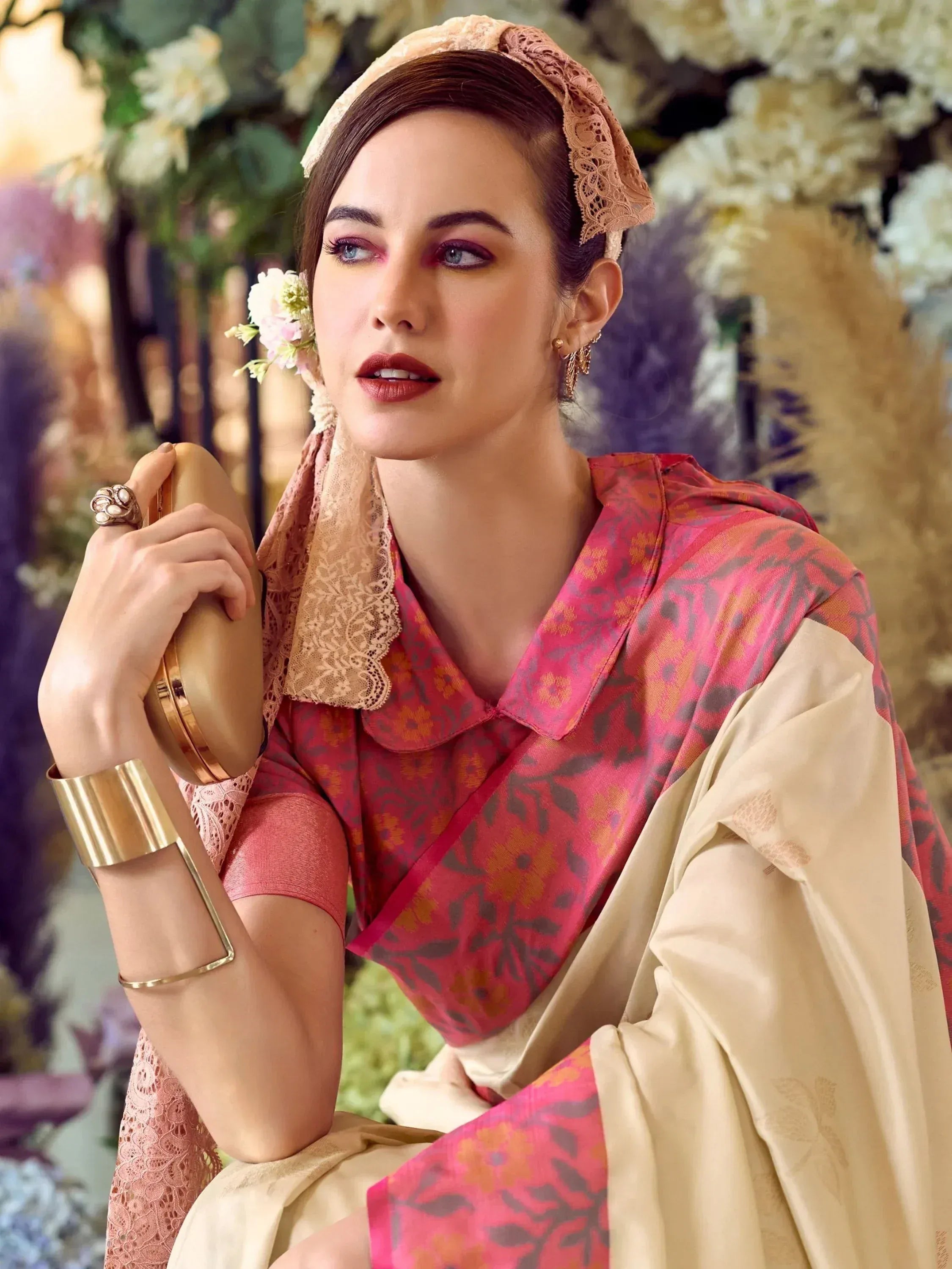 Woman in pink floral ethnic kurta with lace dupatta, gold accessories, and floral headpiece