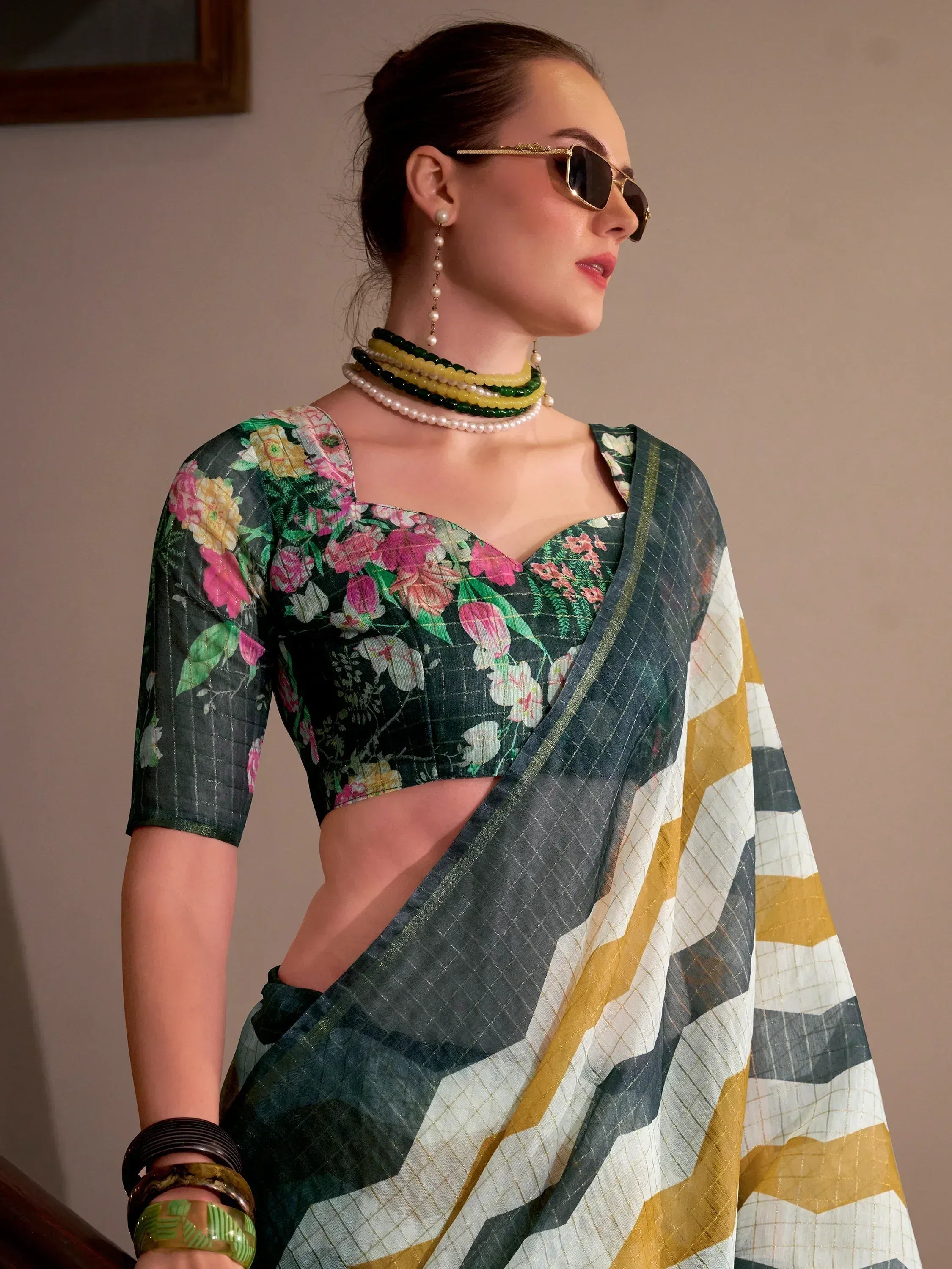 Floral printed saree with geometric border, styled with pearl jewelry and sunglasses
