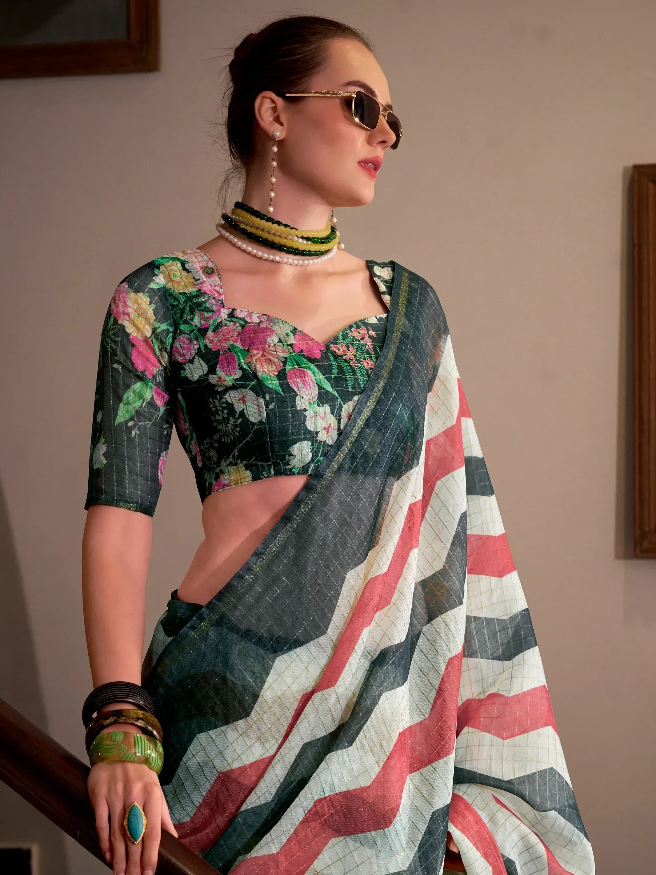 Floral printed saree with geometric border, styled with pearl jewelry and sunglasses