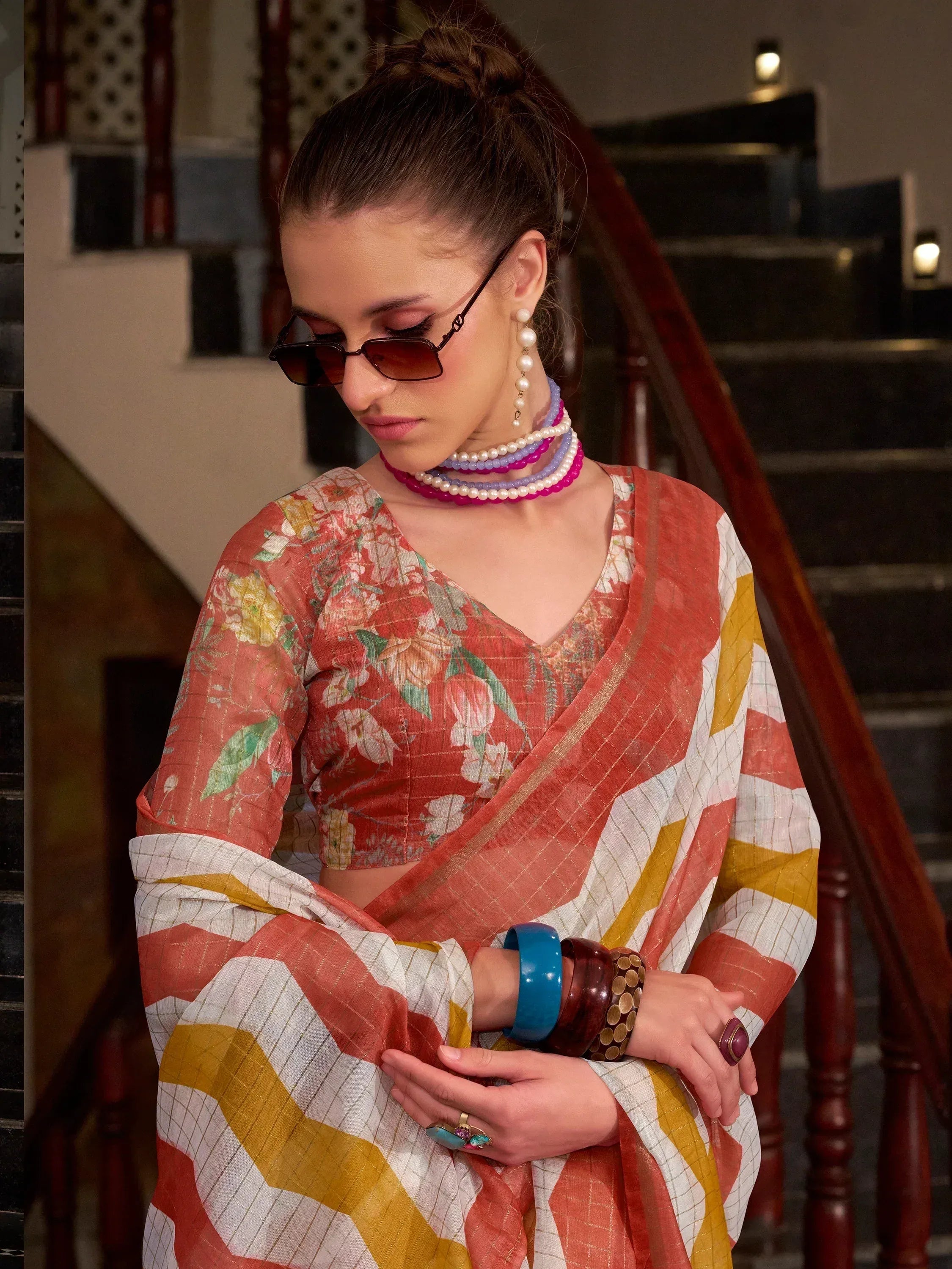 Floral printed ethnic saree with striped pallu, paired with pearl jewelry and sunglasses