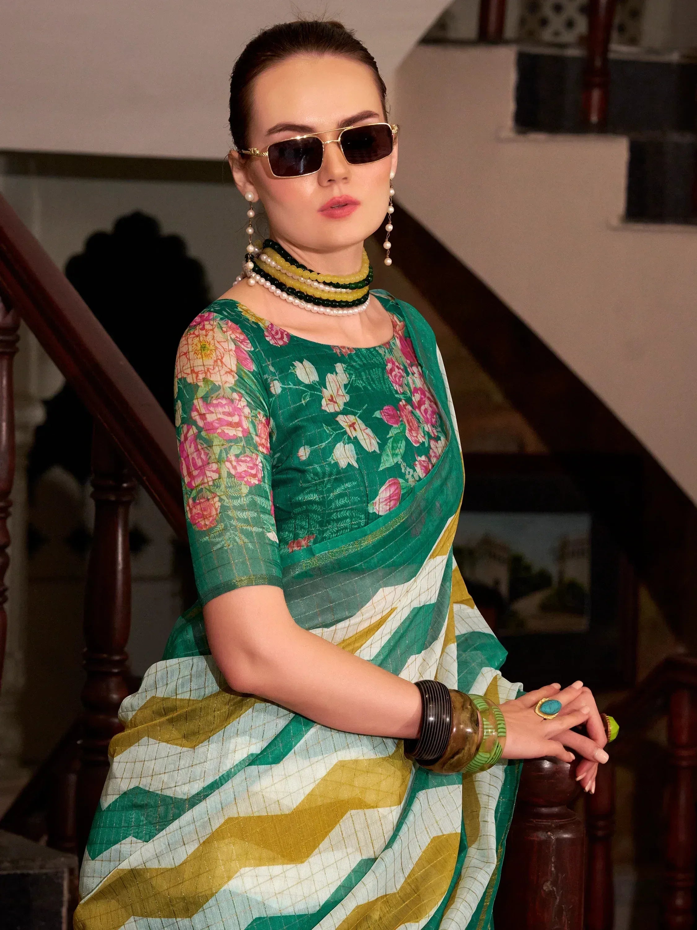 Green floral saree with yellow stripes, styled with pearl jewelry and sunglasses