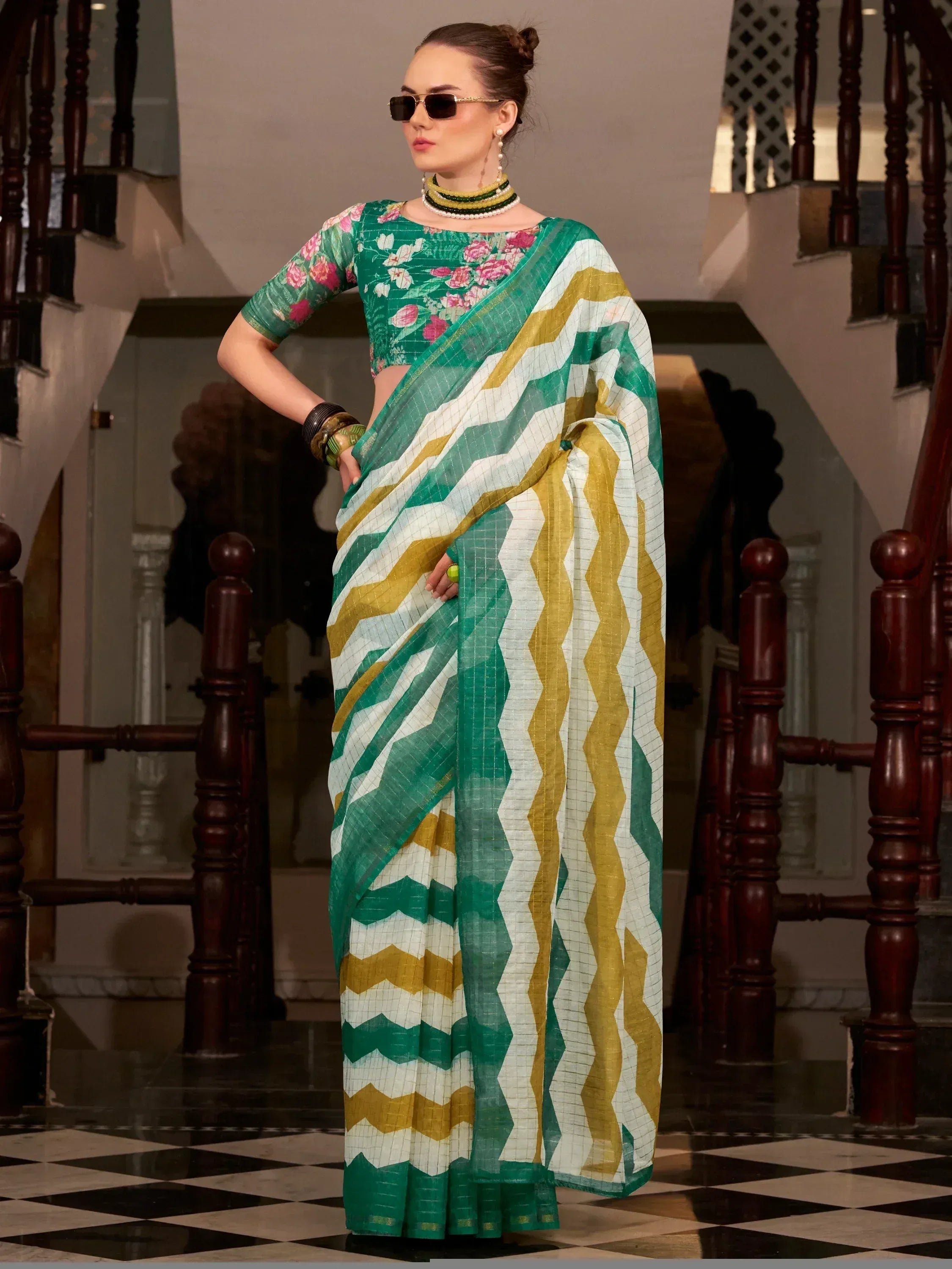 Green and gold zigzag pattern saree with floral blouse, styled with sunglasses and jewelry
