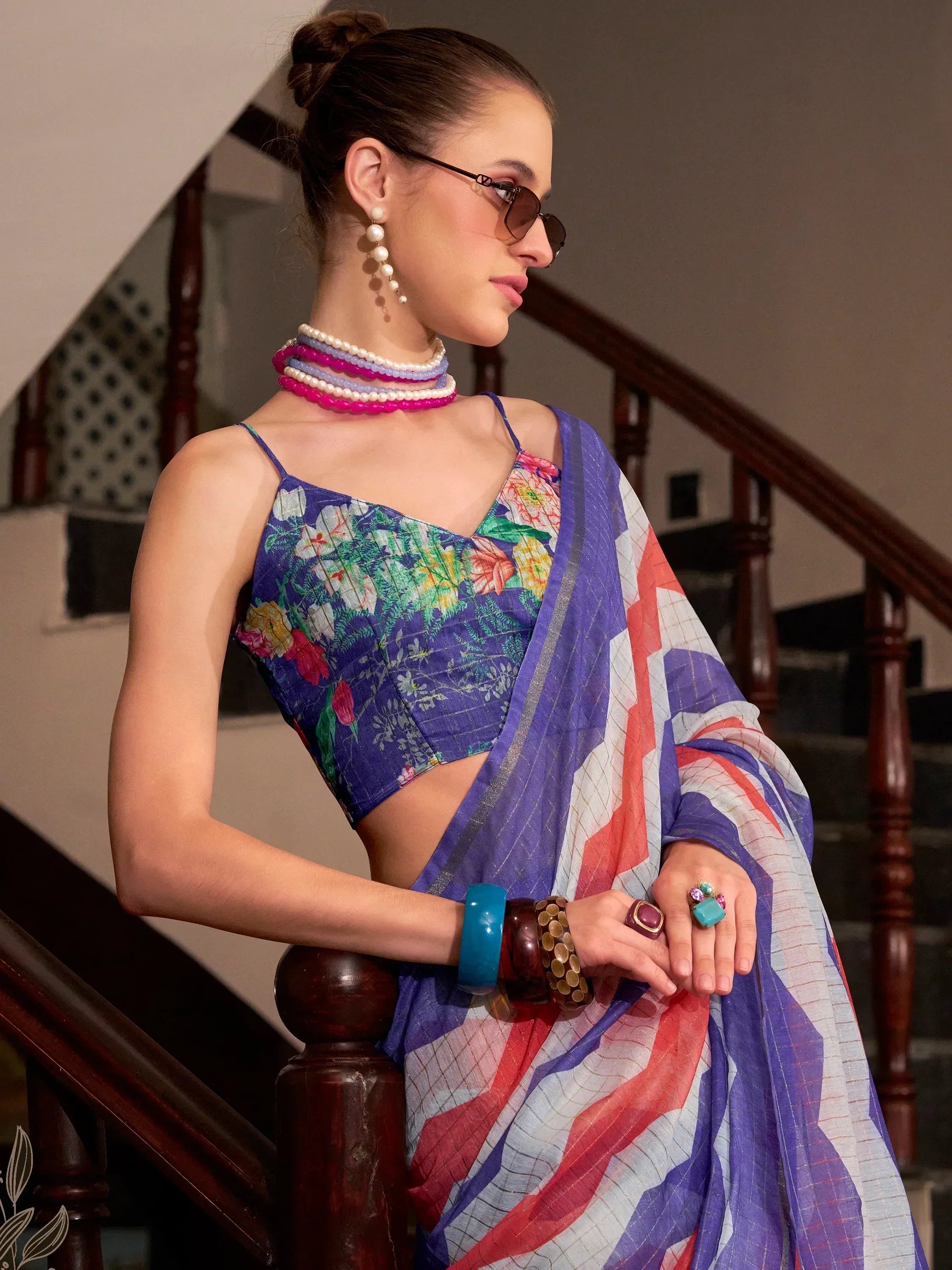Floral printed blue blouse with colorful saree, accessorized with pearl necklaces and bangles