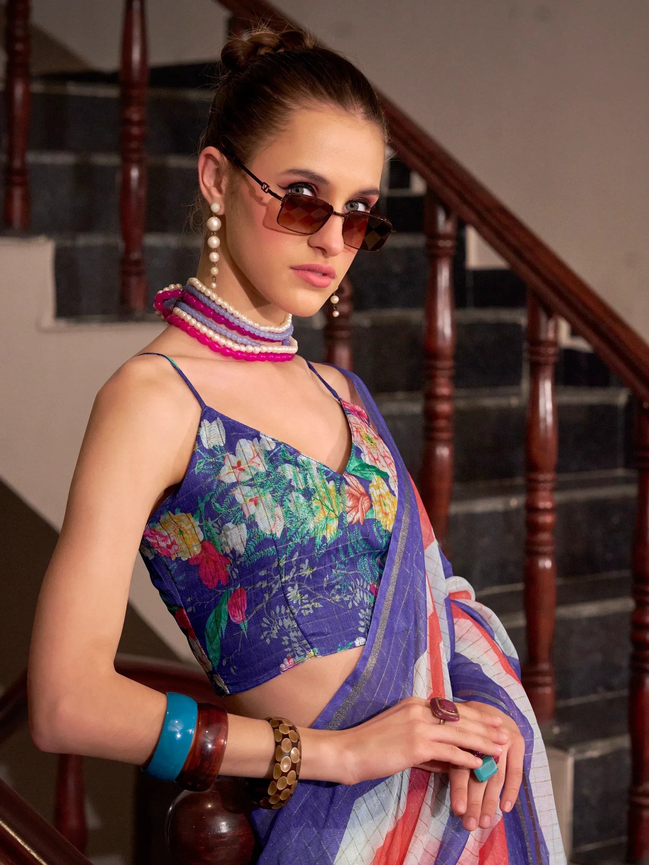 Floral printed blue blouse with saree, accessorized with pearl necklaces and bangles