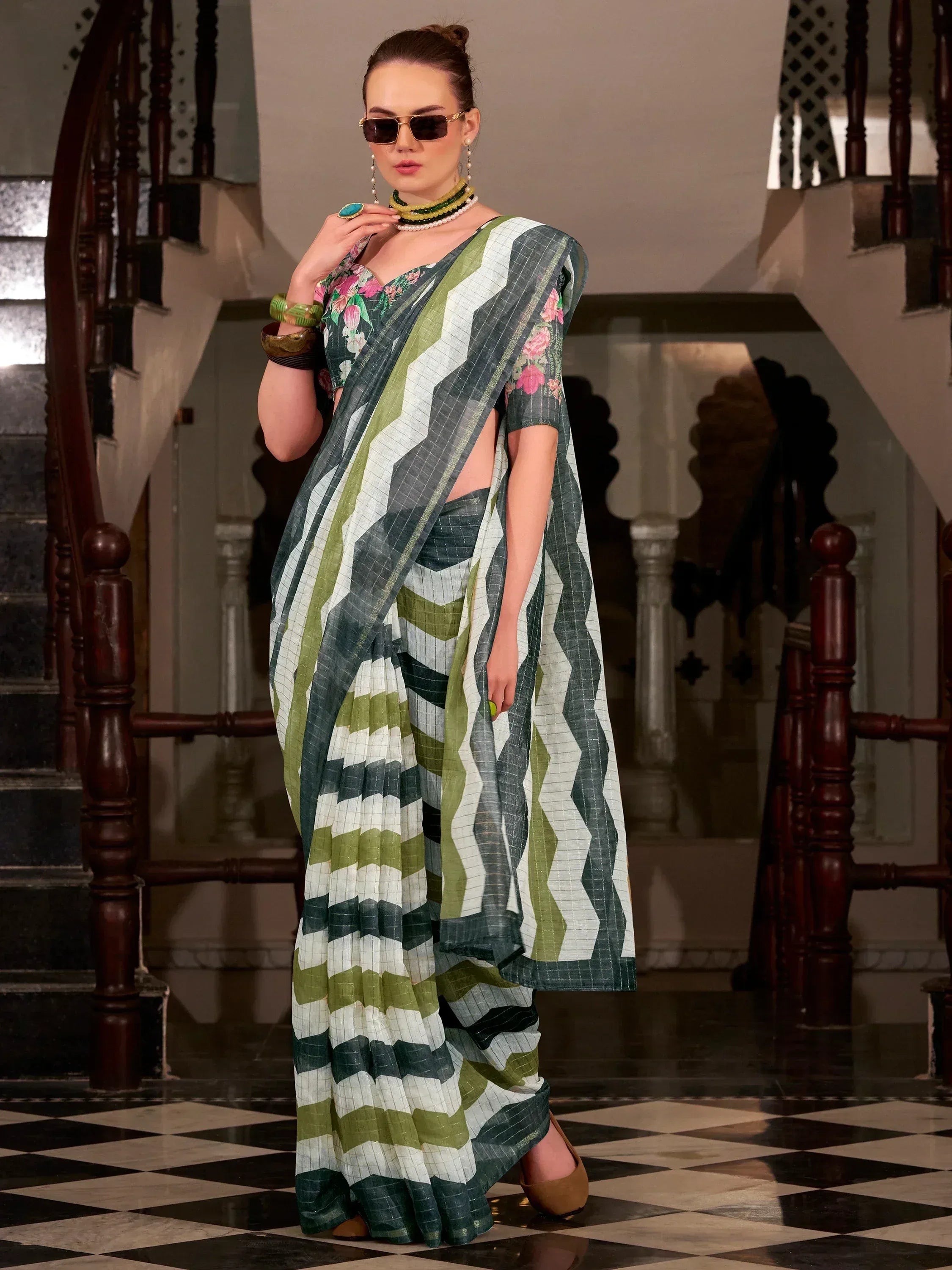 Green and white zigzag pattern saree with floral blouse, styled with sunglasses and jewelry