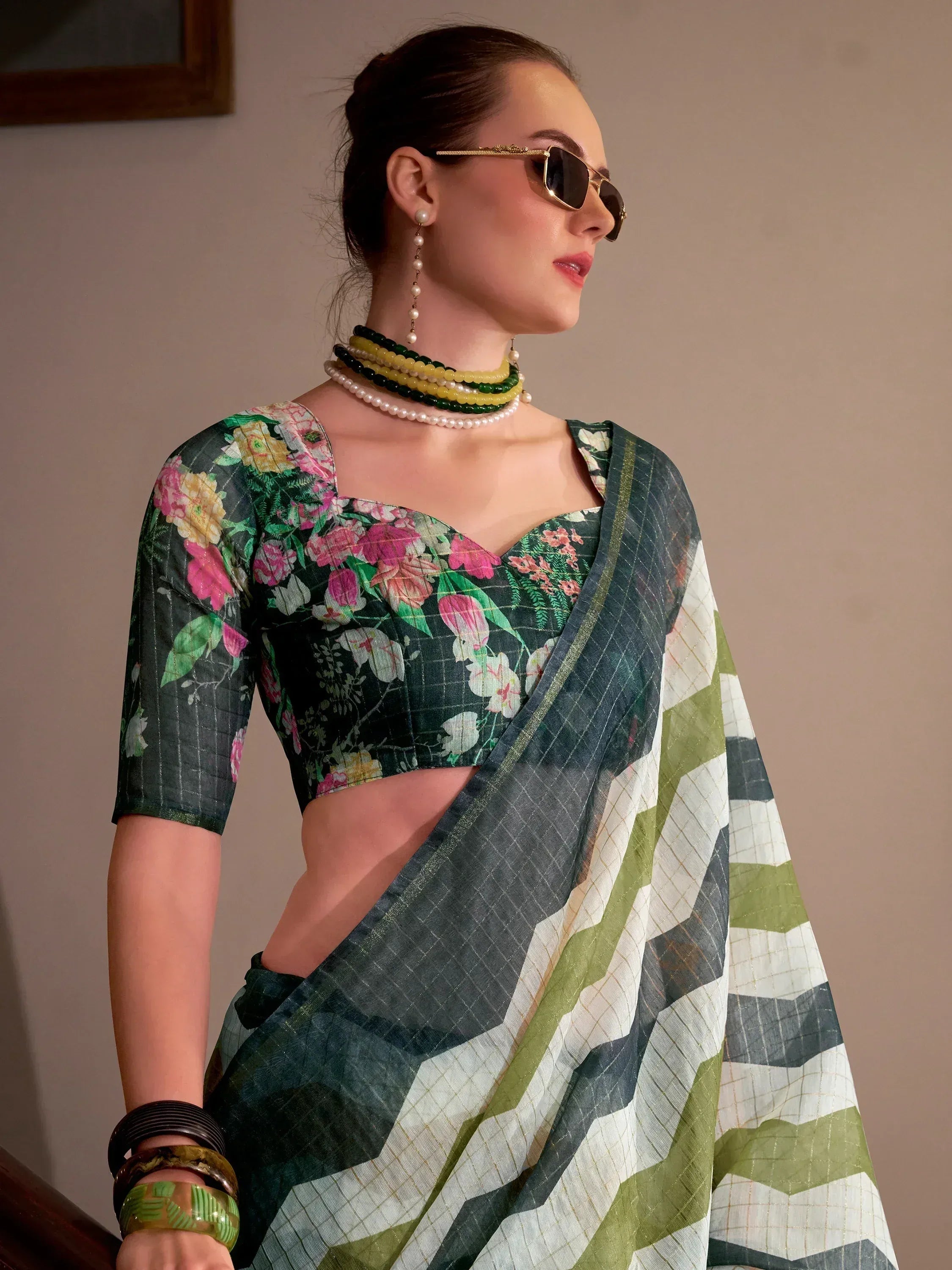 Floral printed saree with geometric border, styled with pearl jewelry and sunglasses