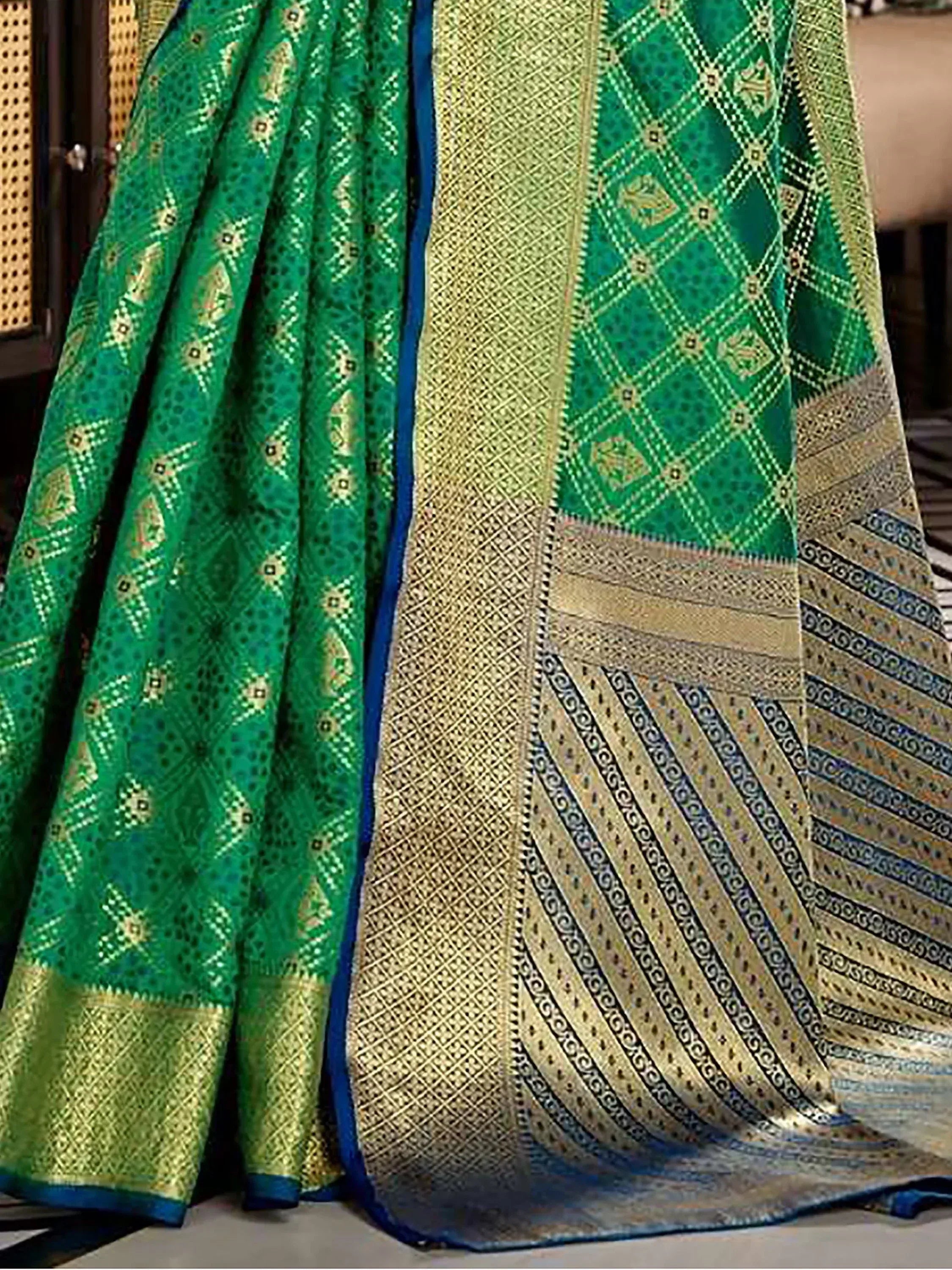 Emerald green designer saree with gold zari work and intricate geometric patterns, perfect for ethnic wear.