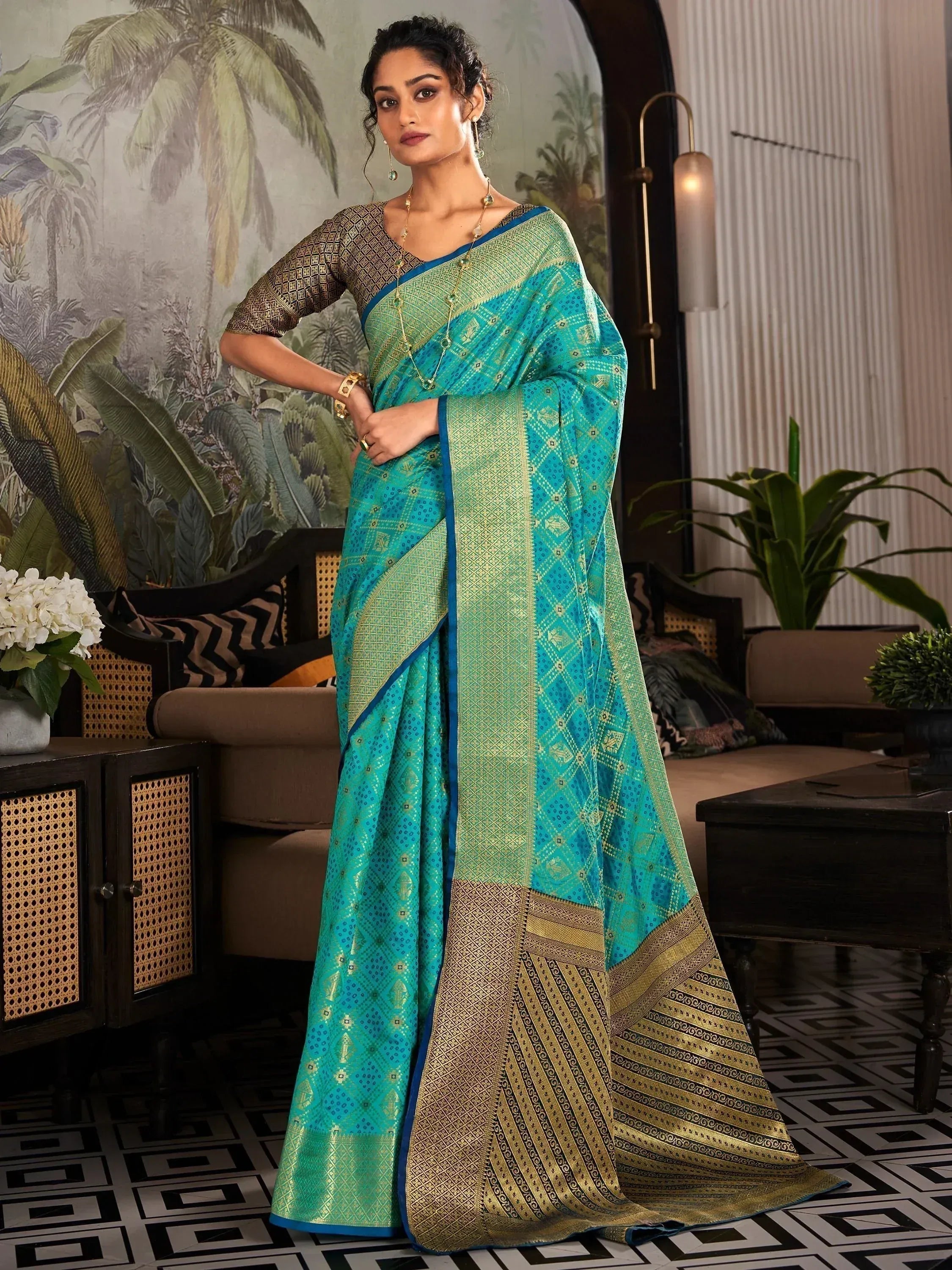 Teal and gold designer saree with intricate geometric patterns, perfect for ethnic occasions