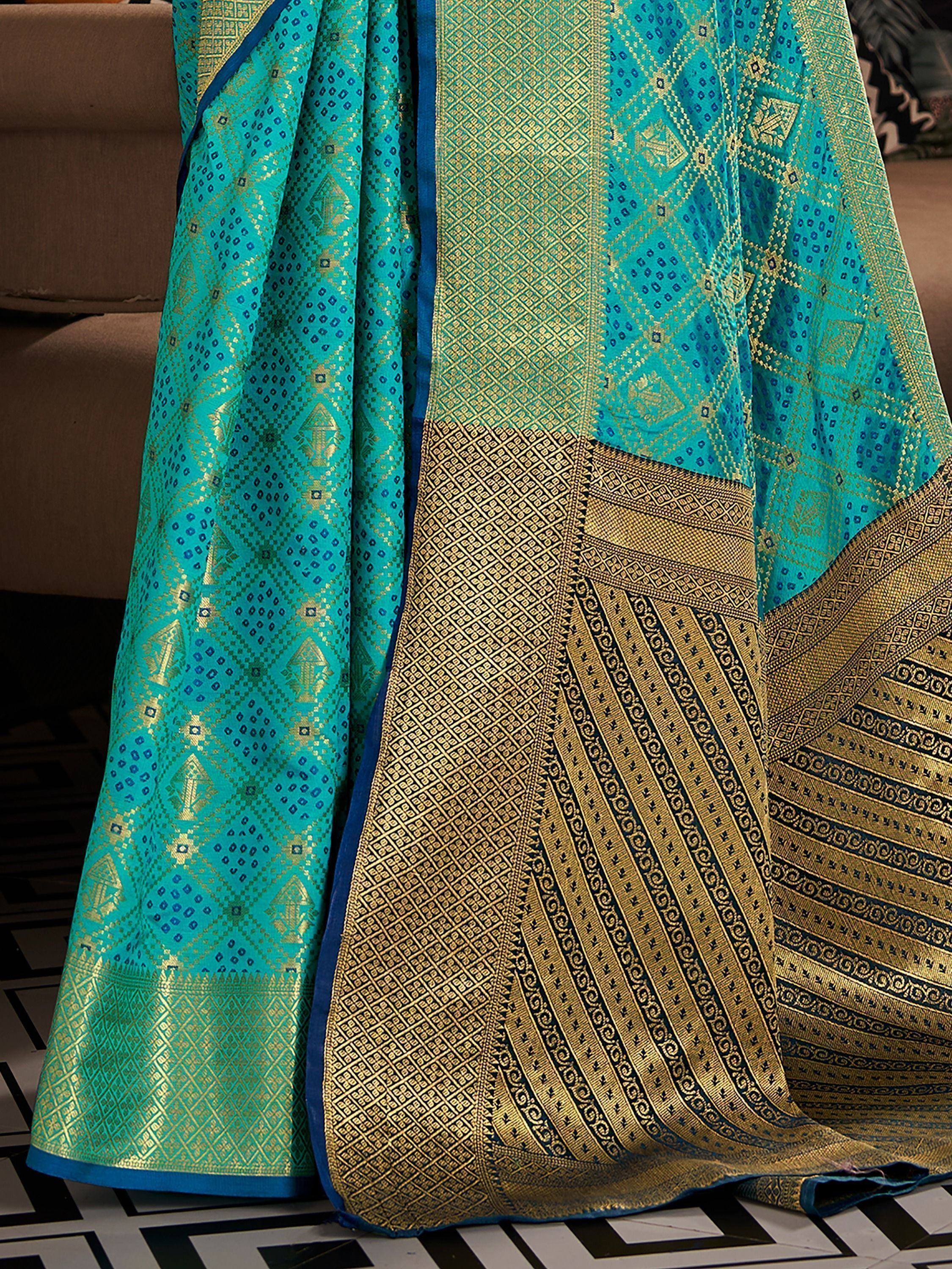 Turquoise and gold designer saree with intricate geometric patterns and rich border detailing