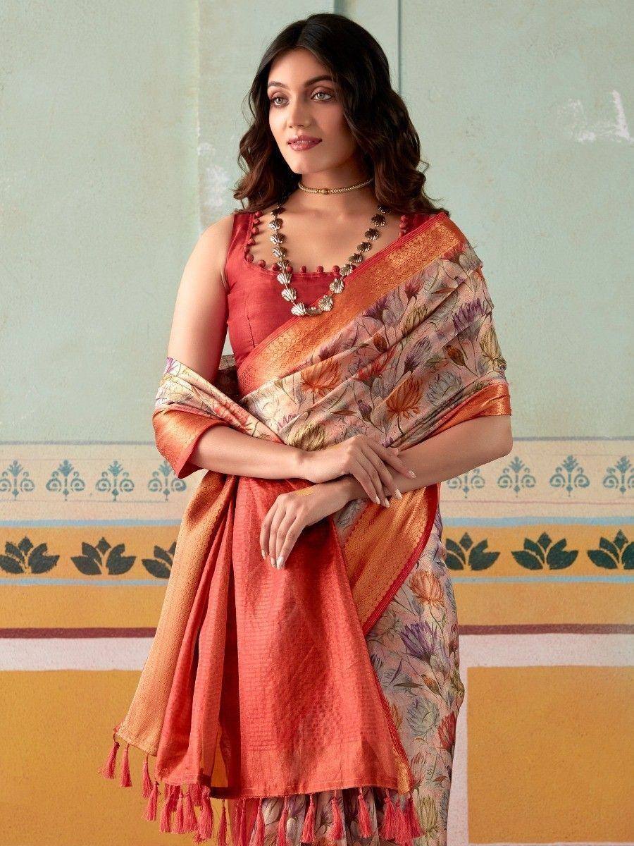 Woman in floral print saree with orange border and tassels, paired with red blouse, ethnic Indian wear