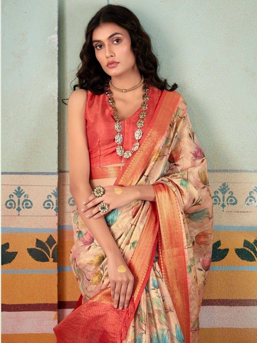 Woman in floral print saree with coral blouse, ethnic jewelry, and traditional Indian attire