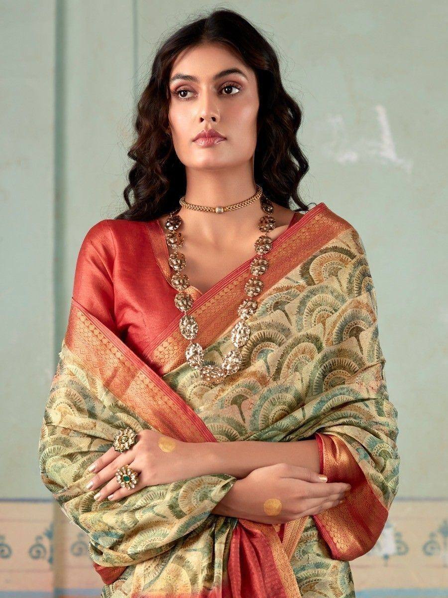 Woman in elegant Indian saree with peacock print, gold jewelry, and red blouse for ethnic wear occasions
