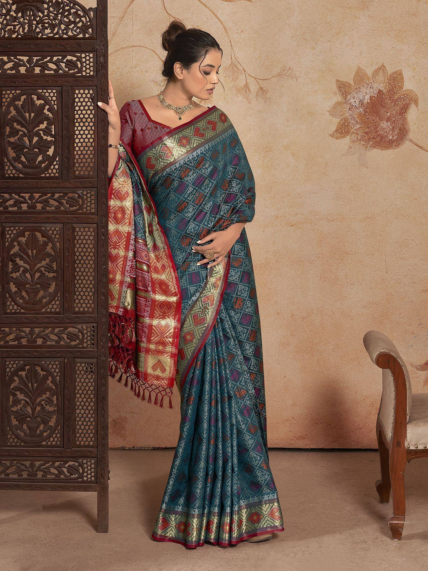 Woman in teal and red ethnic saree with geometric print, traditional Indian wear