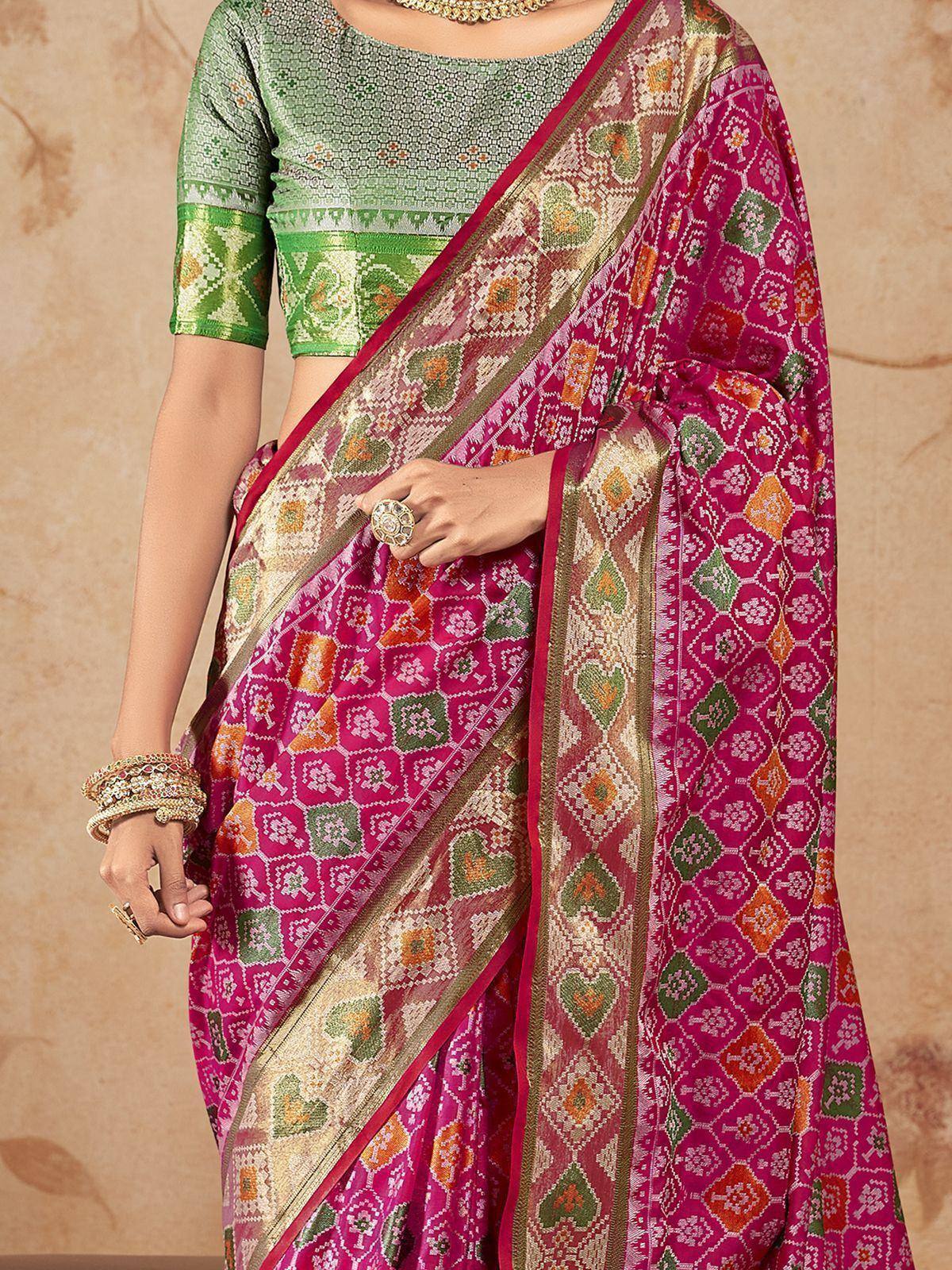 Vibrant pink and green designer saree with intricate geometric patterns, paired with matching blouse for ethnic wear.