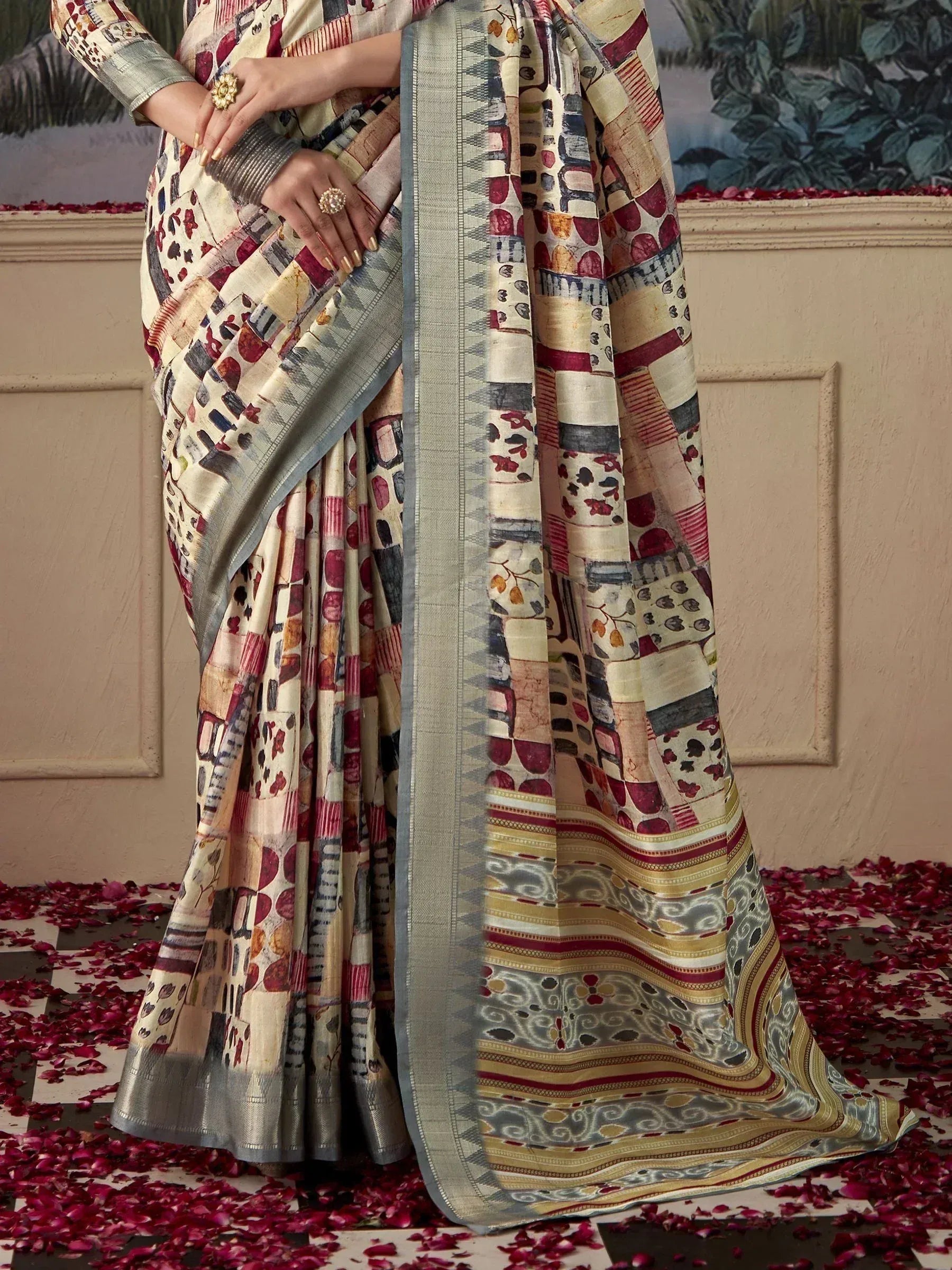 Woman in printed designer saree with silver border, rose petals on floor, ethnic wear