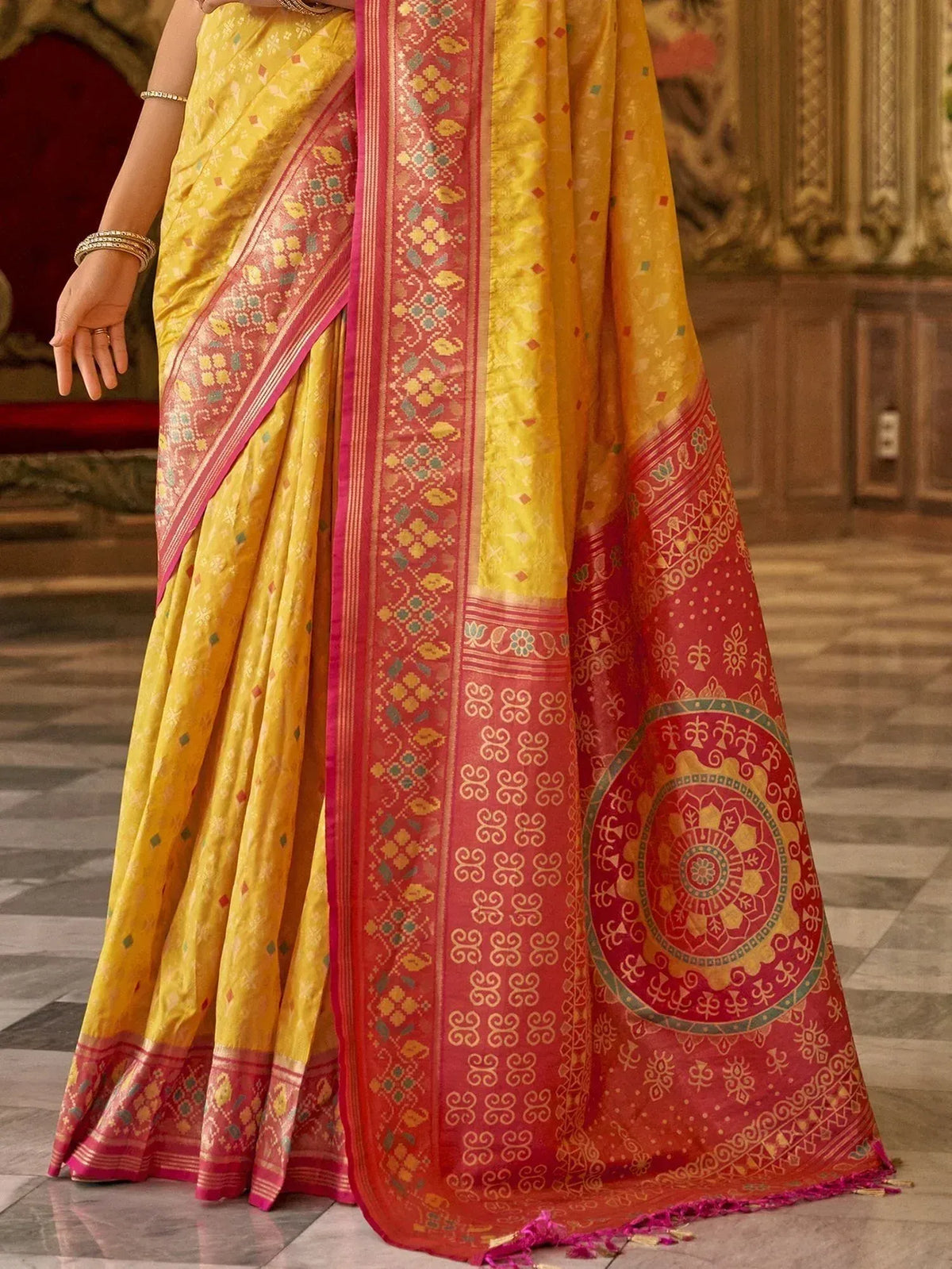 Yellow and red designer saree with intricate floral and geometric patterns, perfect for ethnic occasions.