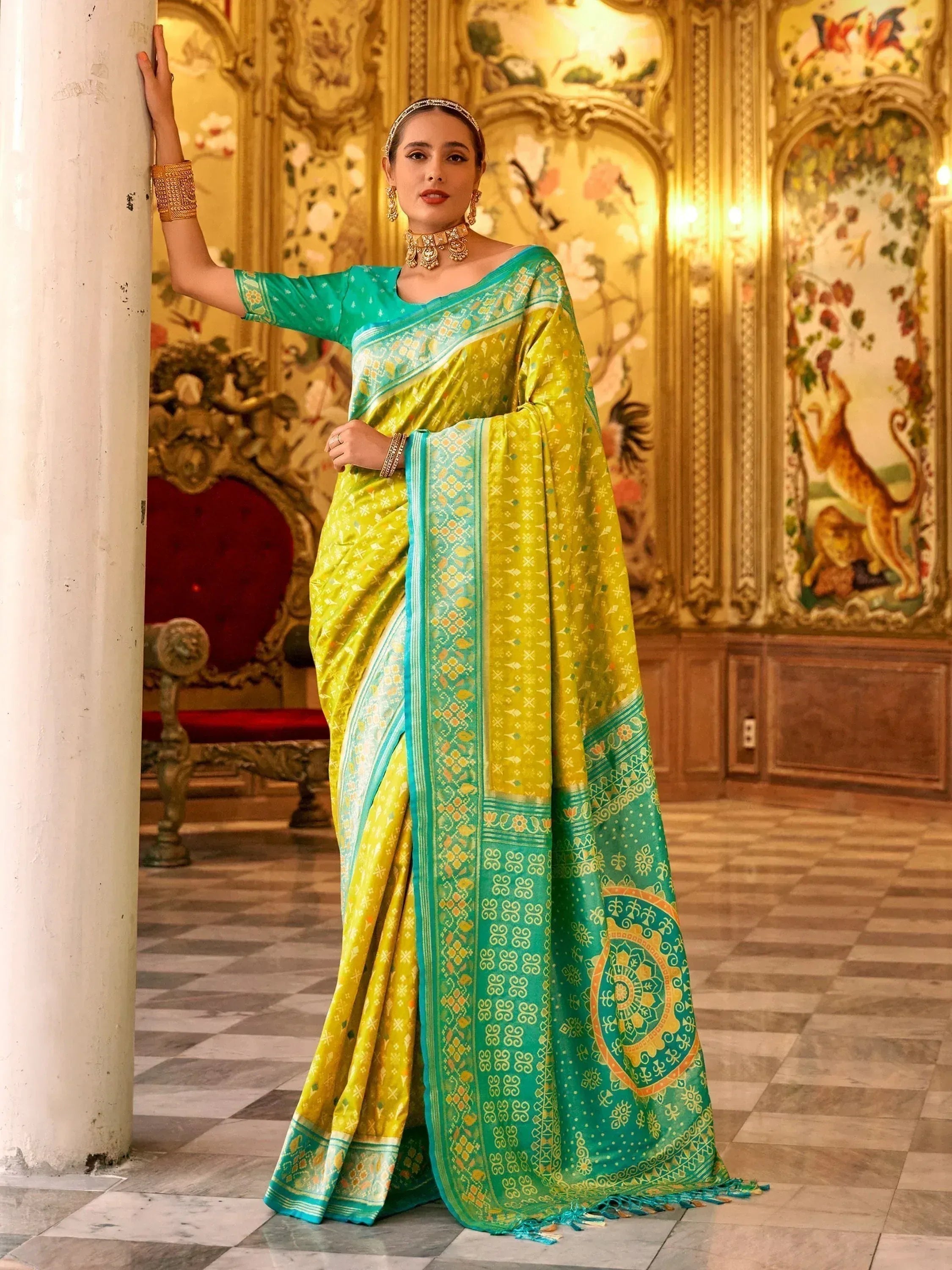Vibrant yellow and teal designer saree with intricate patterns, perfect for ethnic occasions.