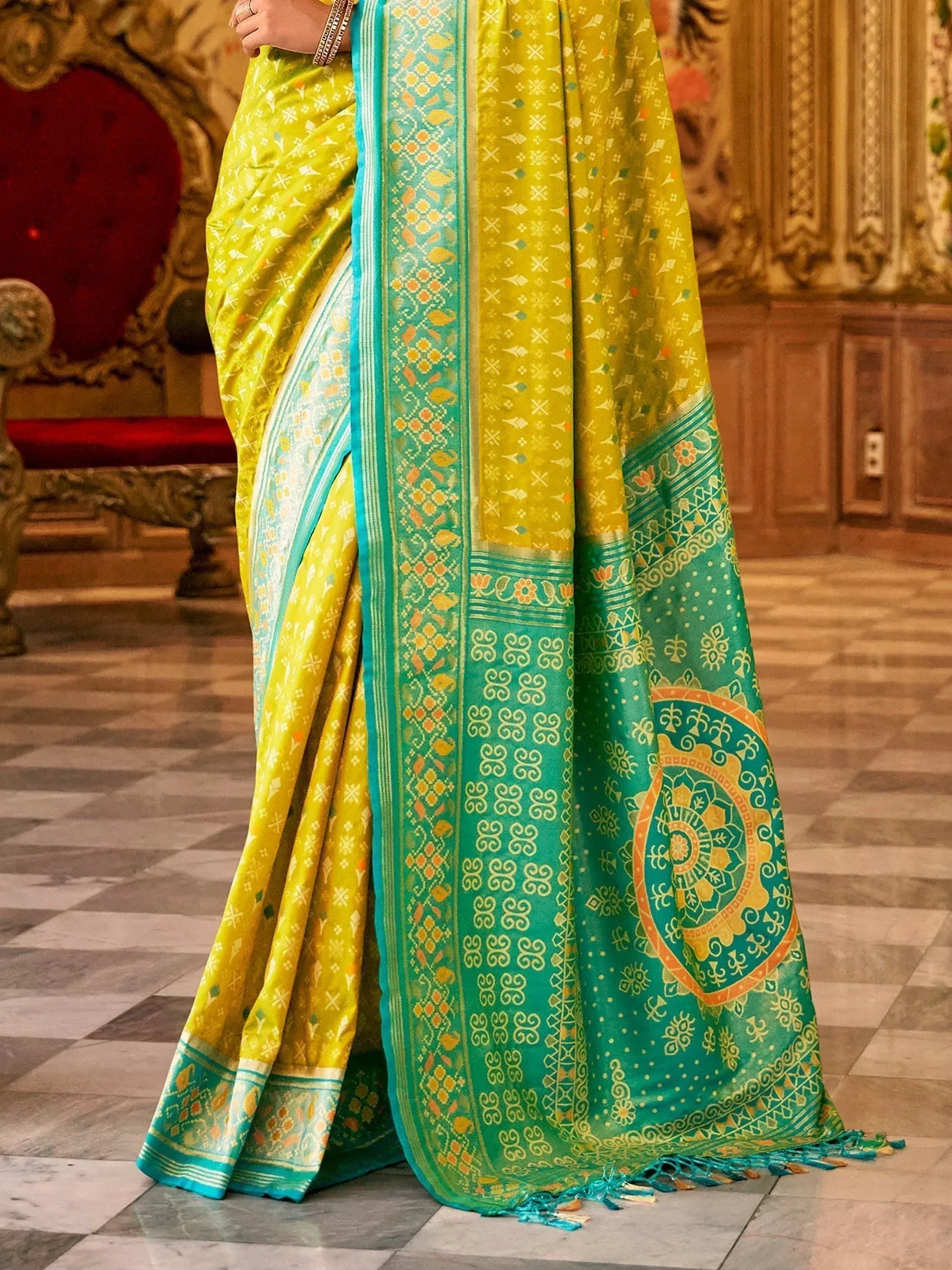 Yellow and teal designer saree with intricate geometric and paisley patterns, perfect for ethnic wear.