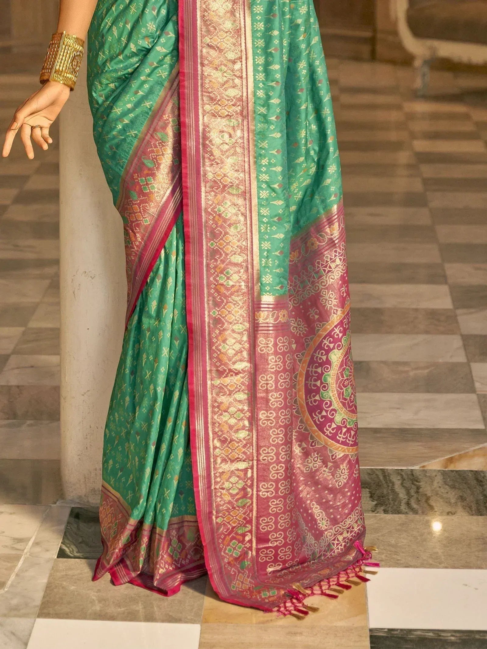 Green and pink designer saree with intricate gold patterns and border, perfect for ethnic occasions