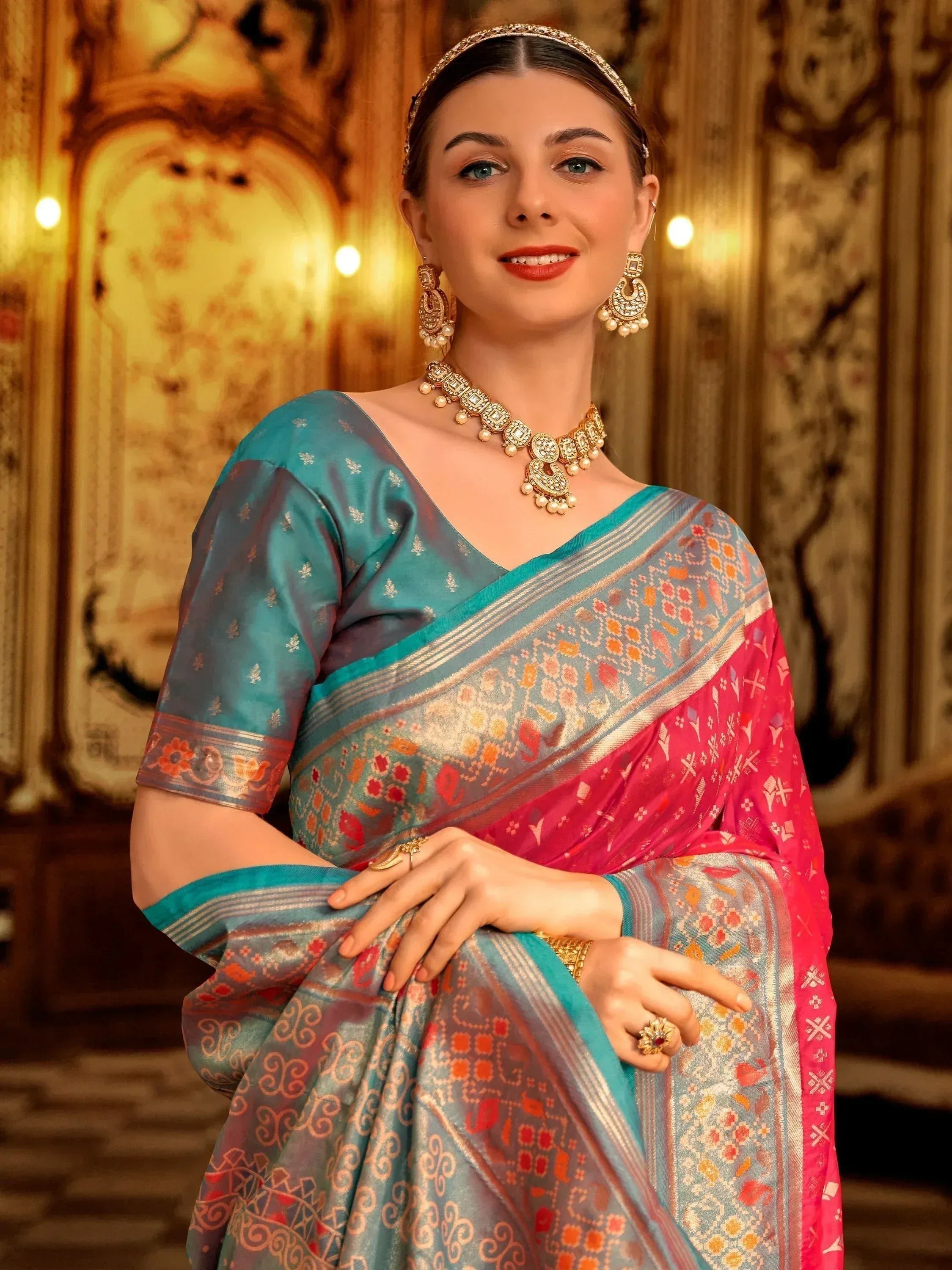 Woman in elegant blue and pink printed saree with gold jewelry, perfect for Indian ethnic occasions