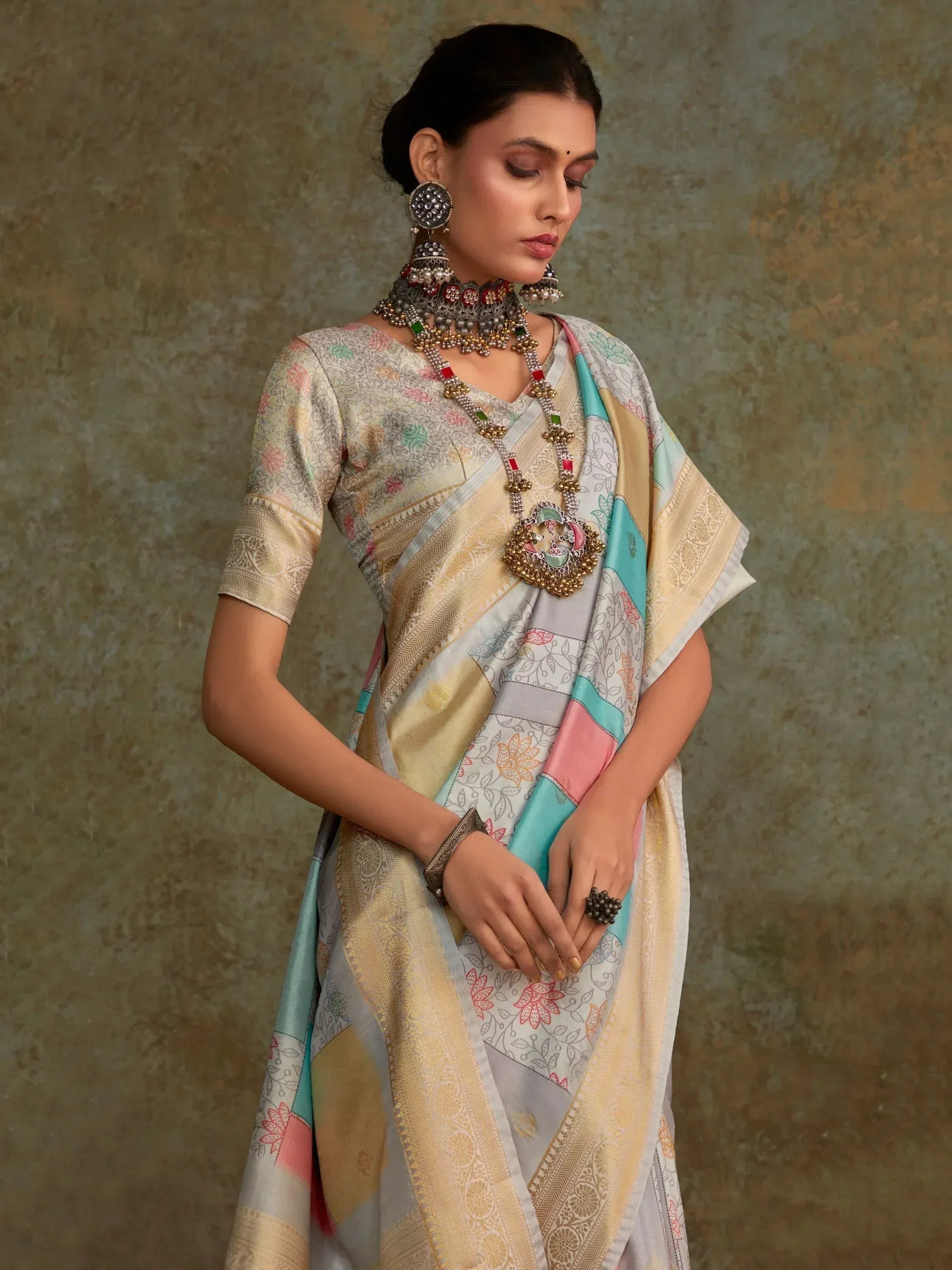 Woman in elegant Indian saree with floral print, gold border, and traditional jewelry for ethnic wear