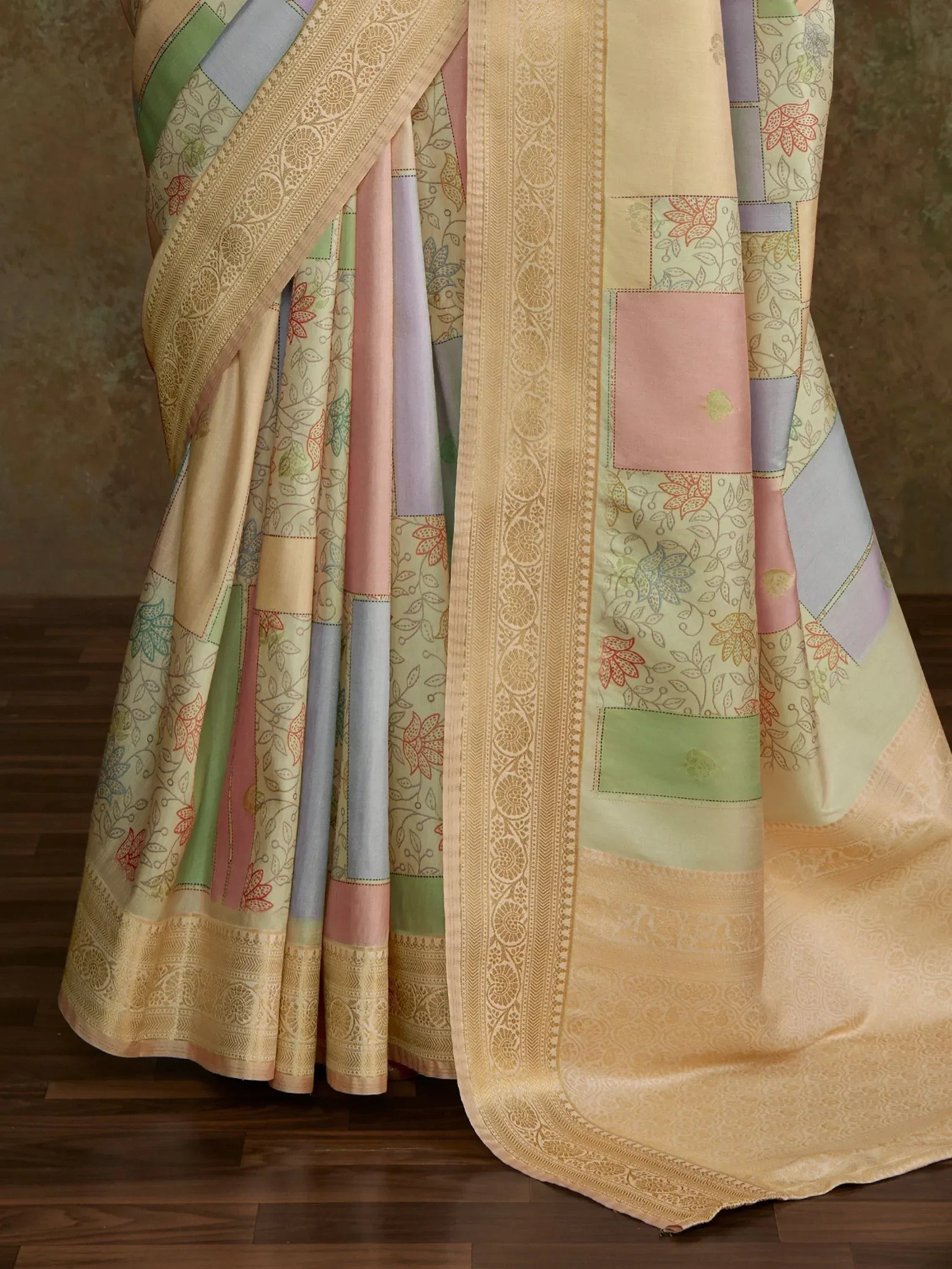 Pastel patchwork saree with floral prints and golden border, ideal for ethnic occasions