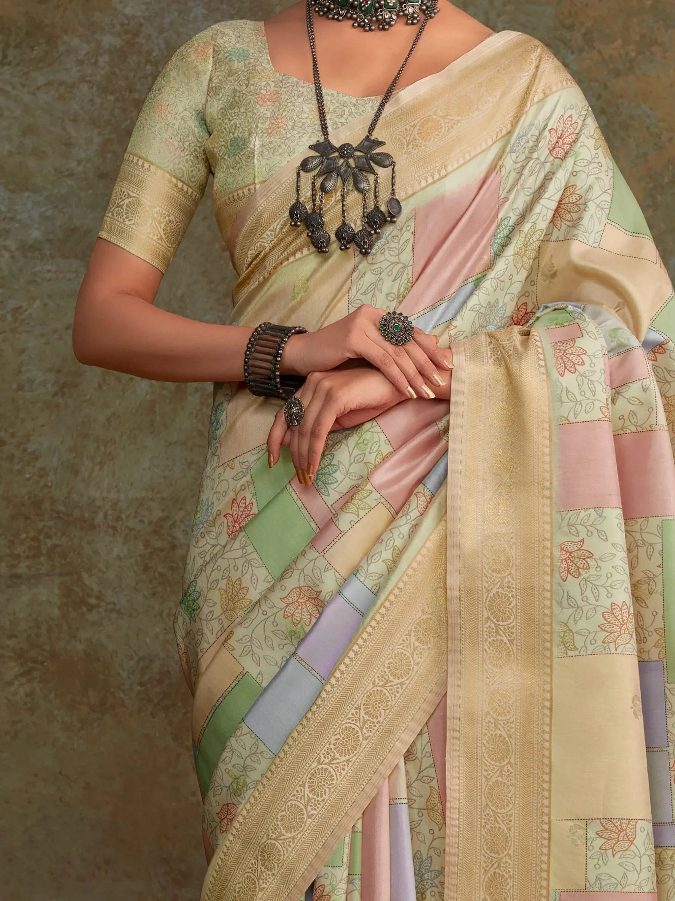 Pastel patchwork saree with floral print and gold border, paired with matching blouse and ethnic jewelry