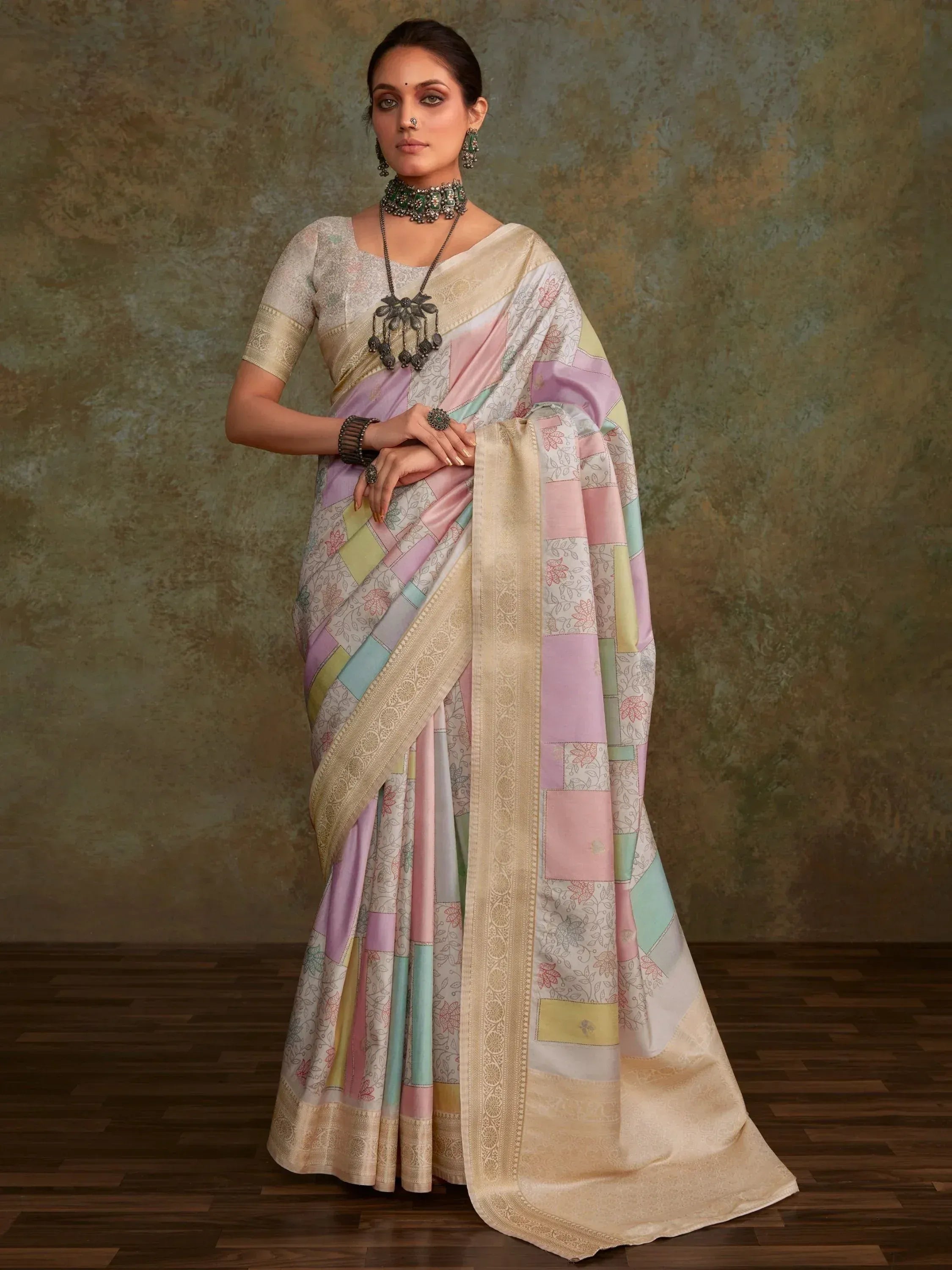 Pastel patchwork saree with floral print and gold border, styled with traditional jewelry for ethnic wear.