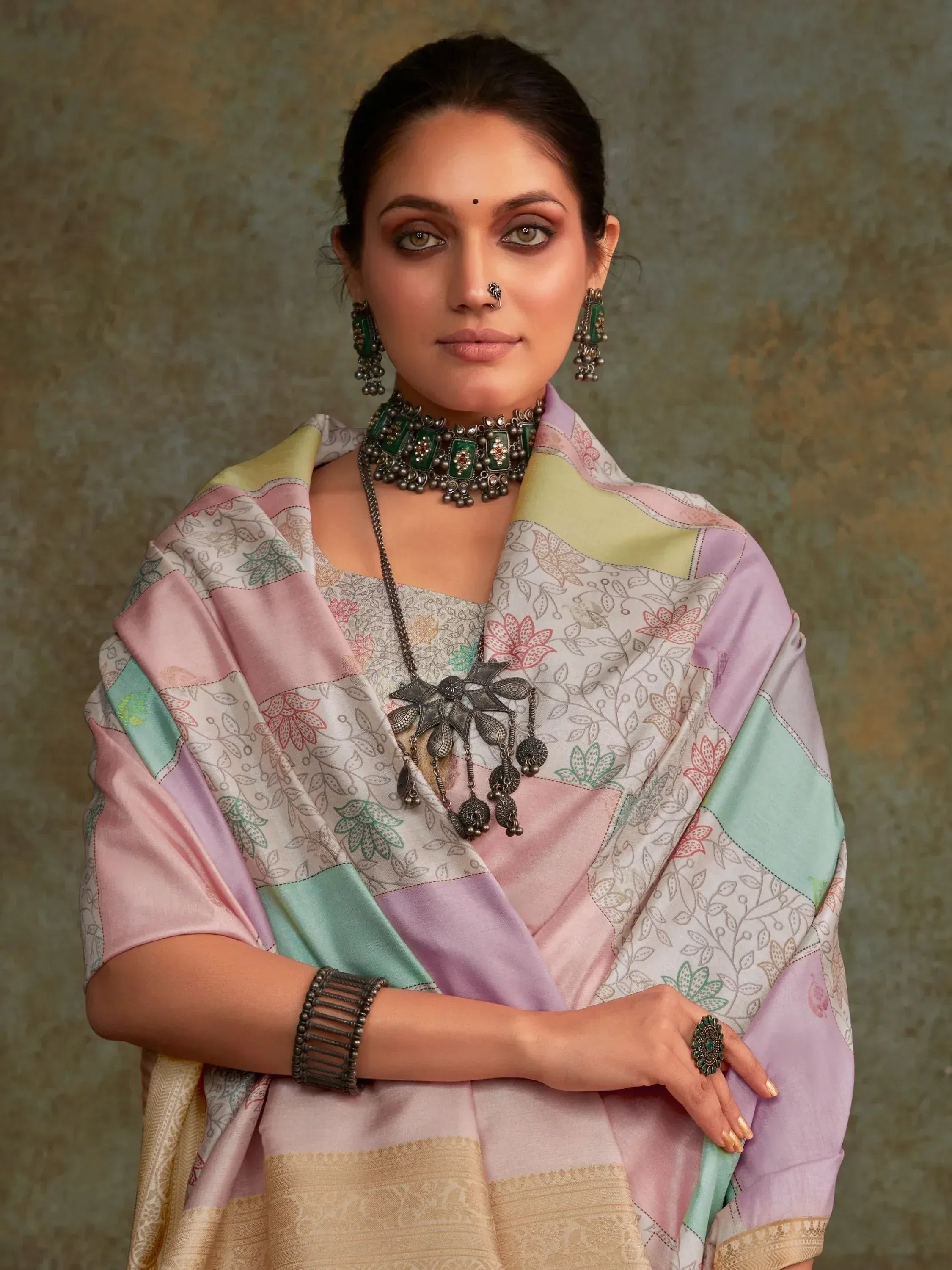 Woman in pastel patchwork saree with floral print, ethnic jewelry, and nose ring