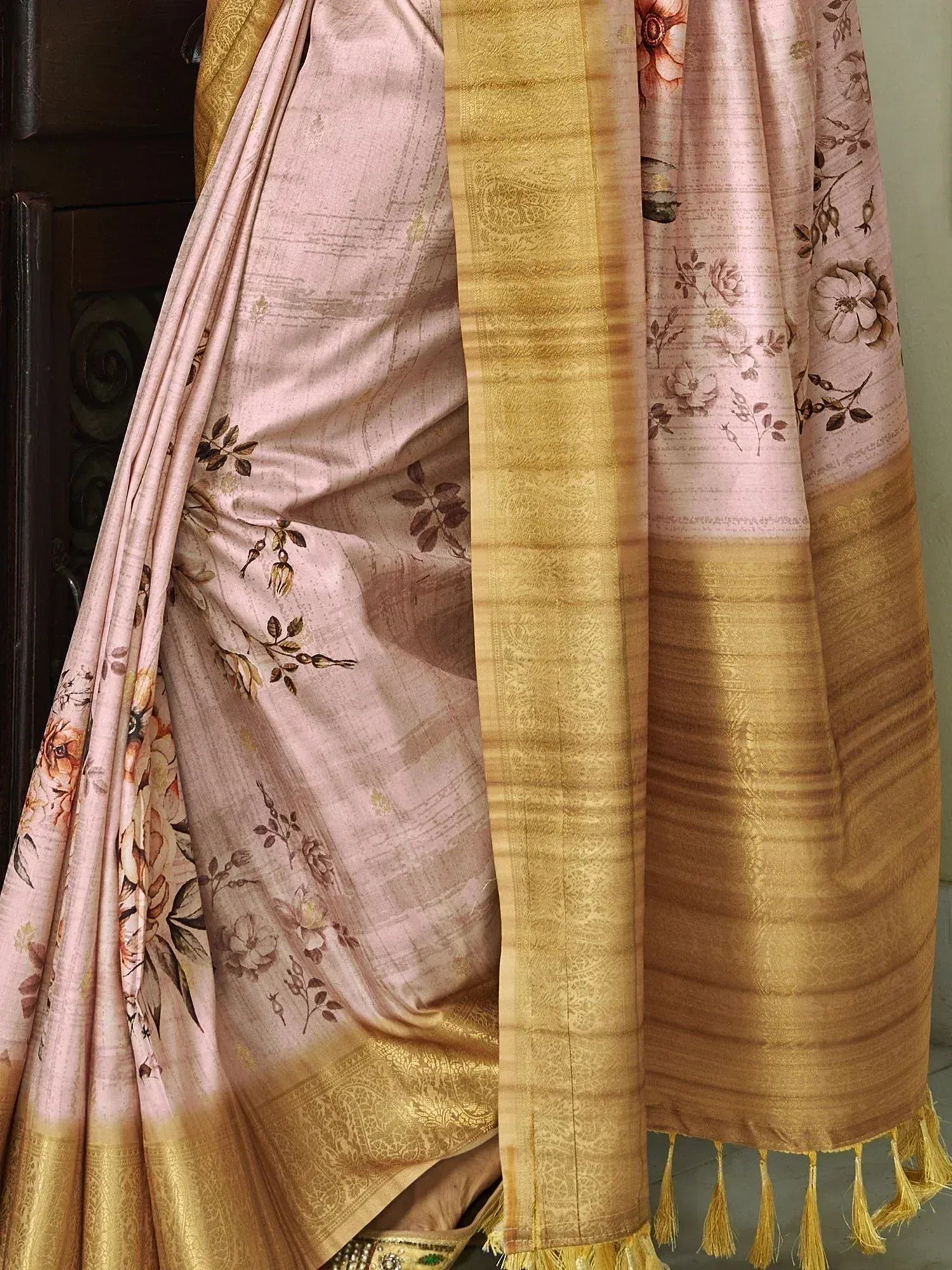 Elegant pink floral saree with golden border and tassels, perfect for ethnic occasions