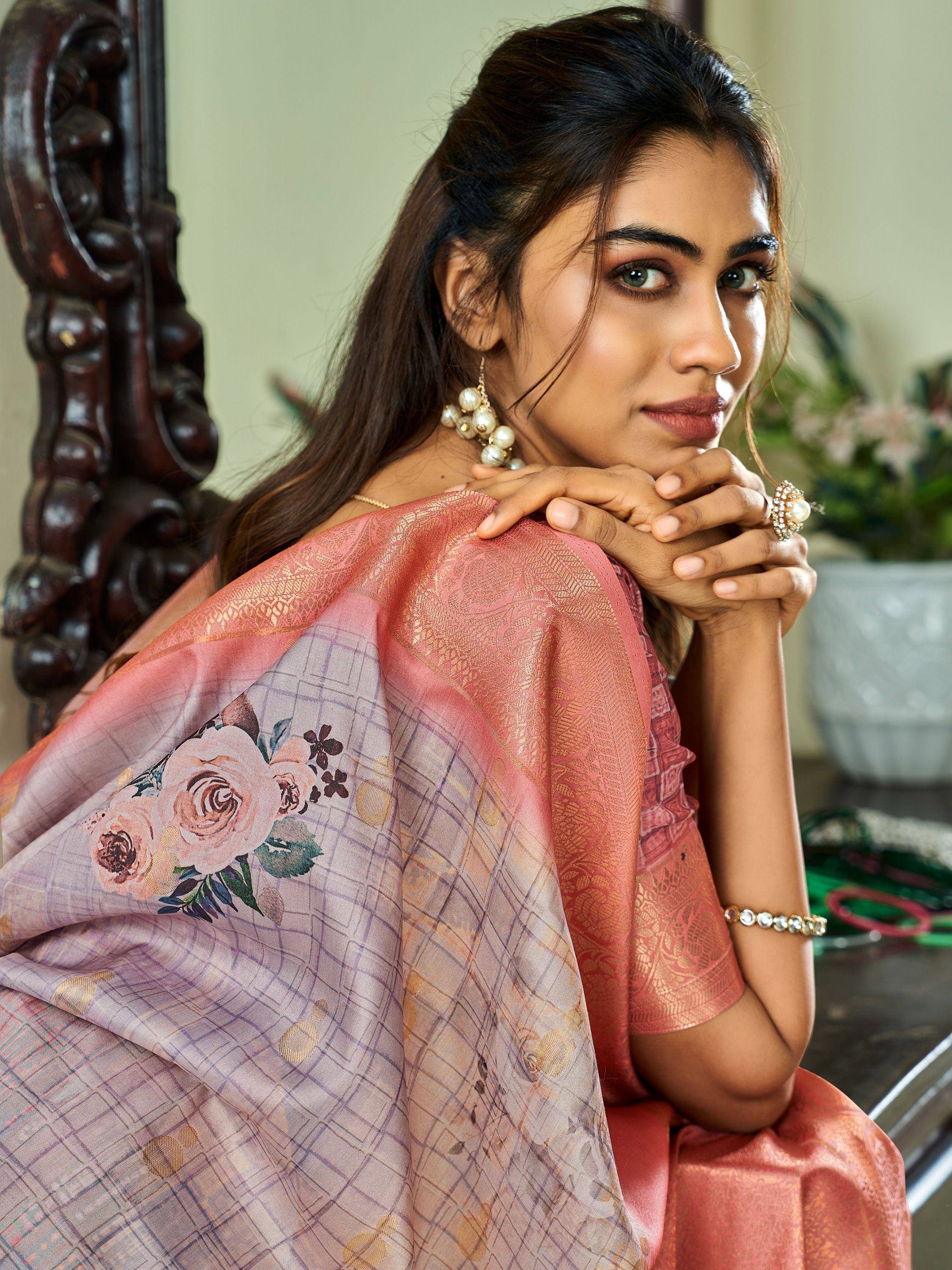 Elegant woman in floral printed saree with golden accents, styled with pearl earrings and bracelet.