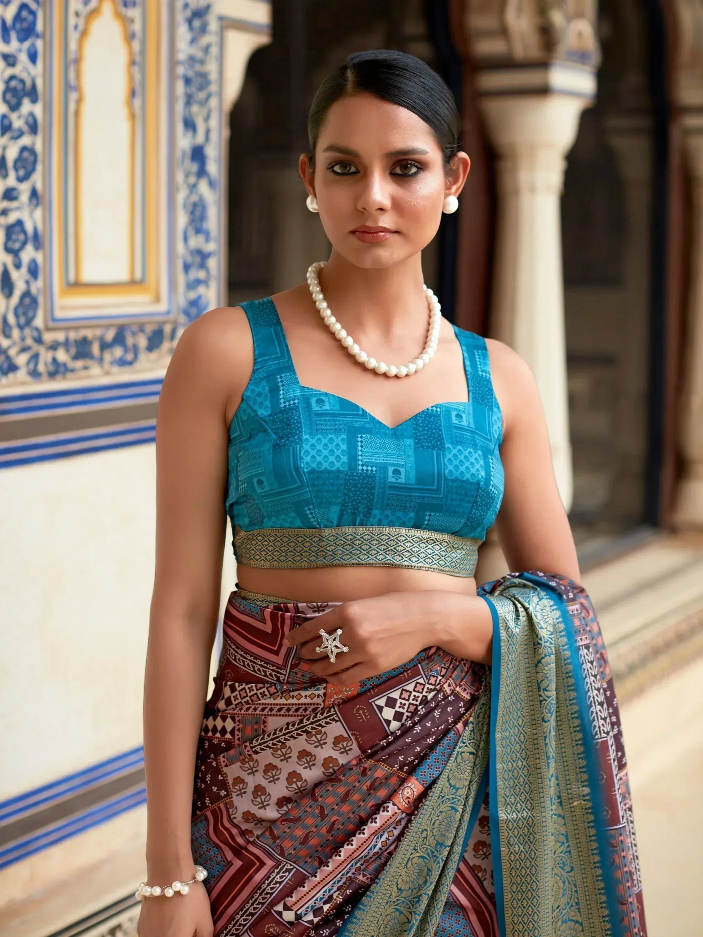 Woman in blue printed blouse and patterned saree with pearl jewelry, Indian ethnic wear