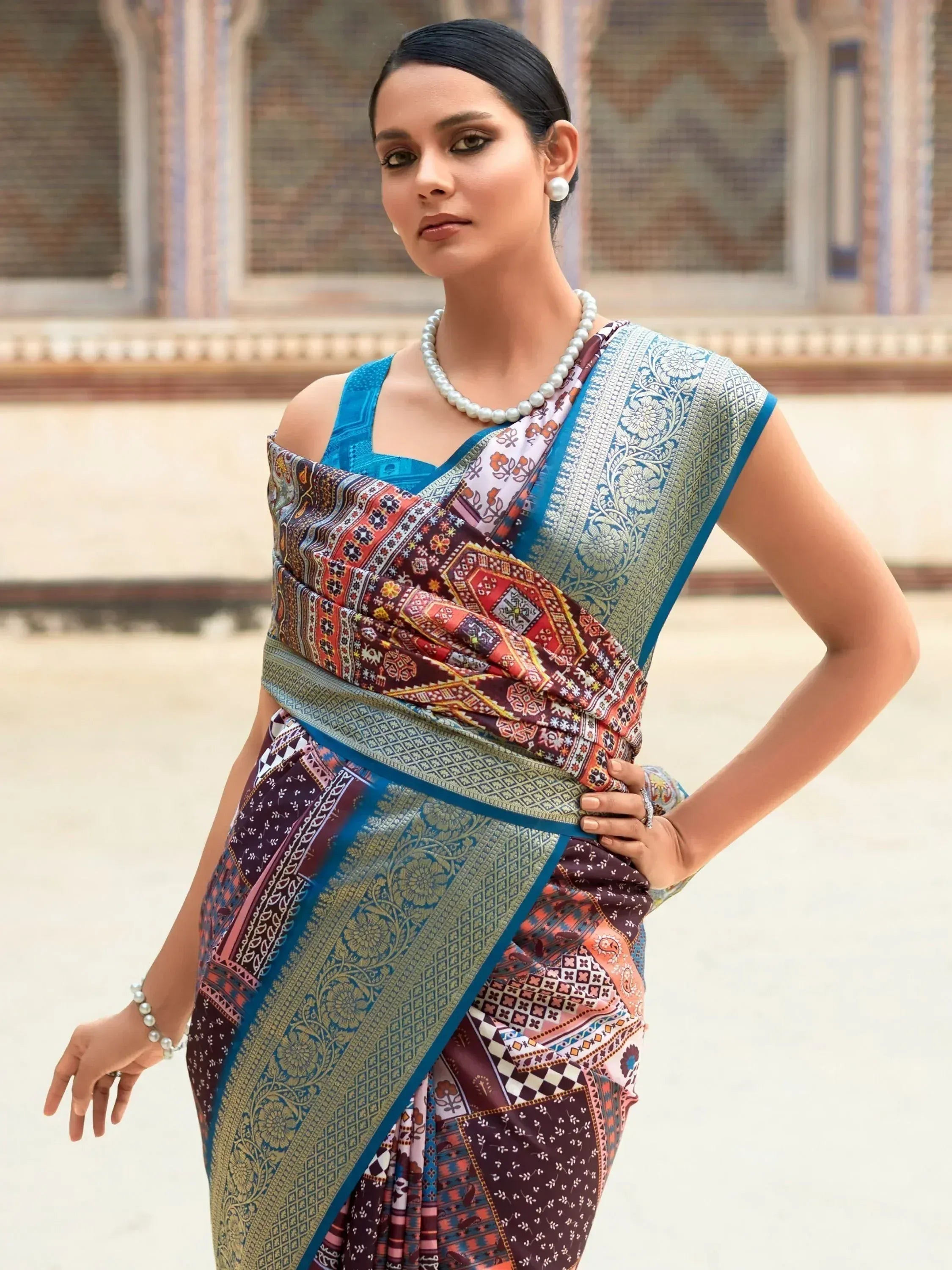 Woman in colorful printed saree with blue blouse and pearl jewelry, Indian ethnic wear