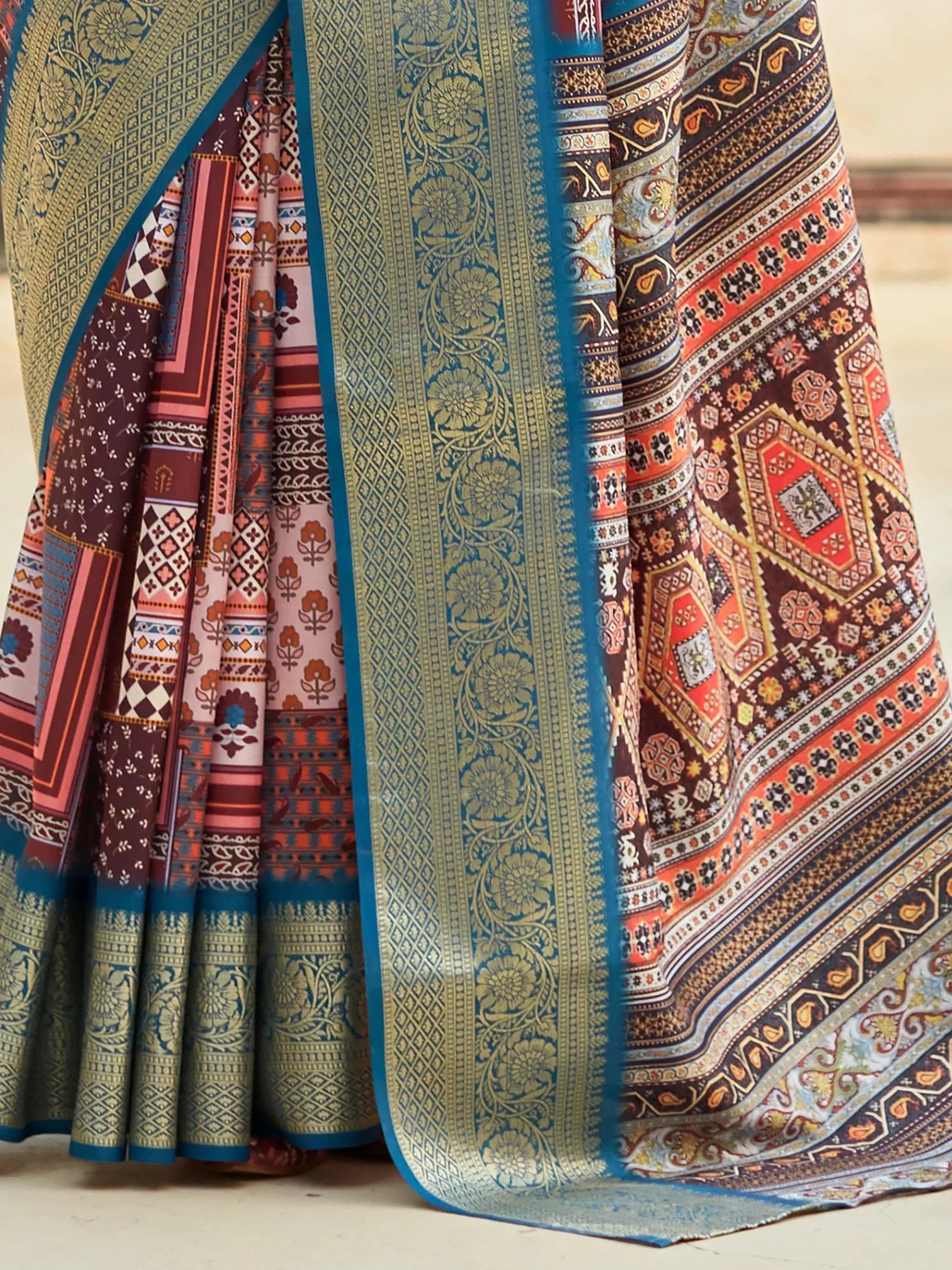 Elegant Indian saree with intricate floral and geometric patterns in teal, gold, and maroon, perfect for ethnic wear.