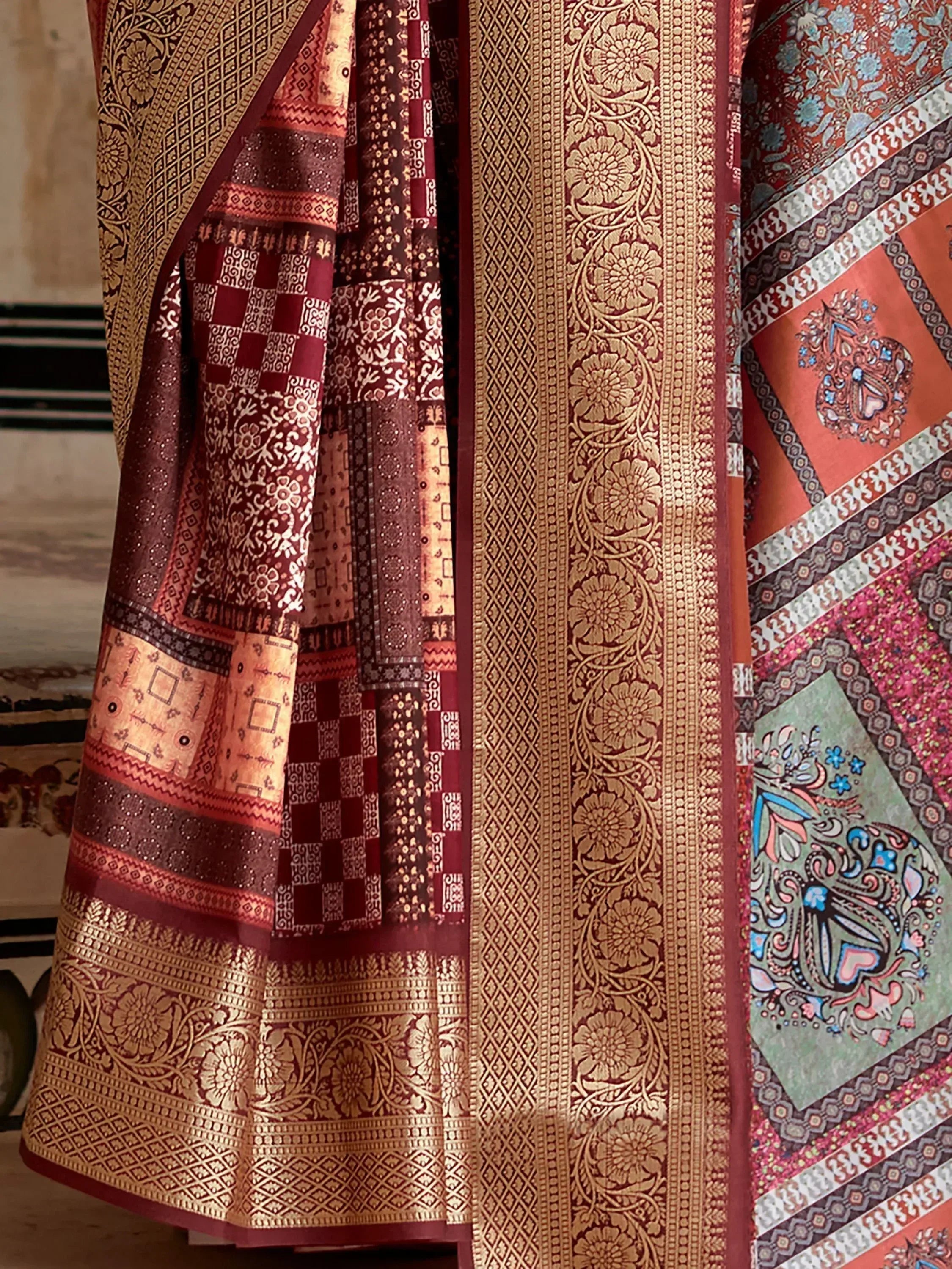 Rich maroon and gold ethnic saree with intricate floral and geometric patterns, perfect for traditional Indian occasions.