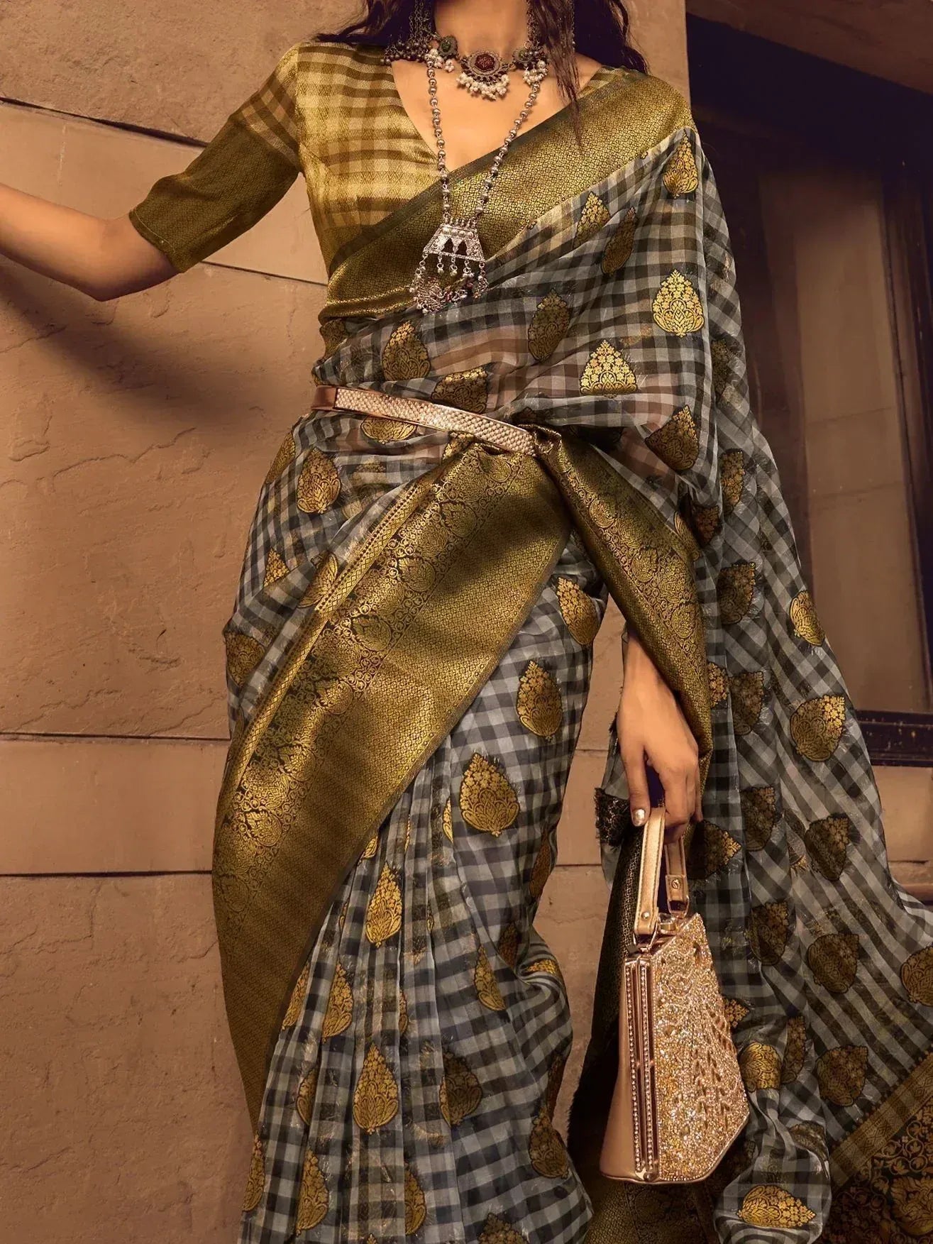 Elegant checkered saree with gold leaf motifs, paired with a matching blouse and ornate jewelry for festive occasions.