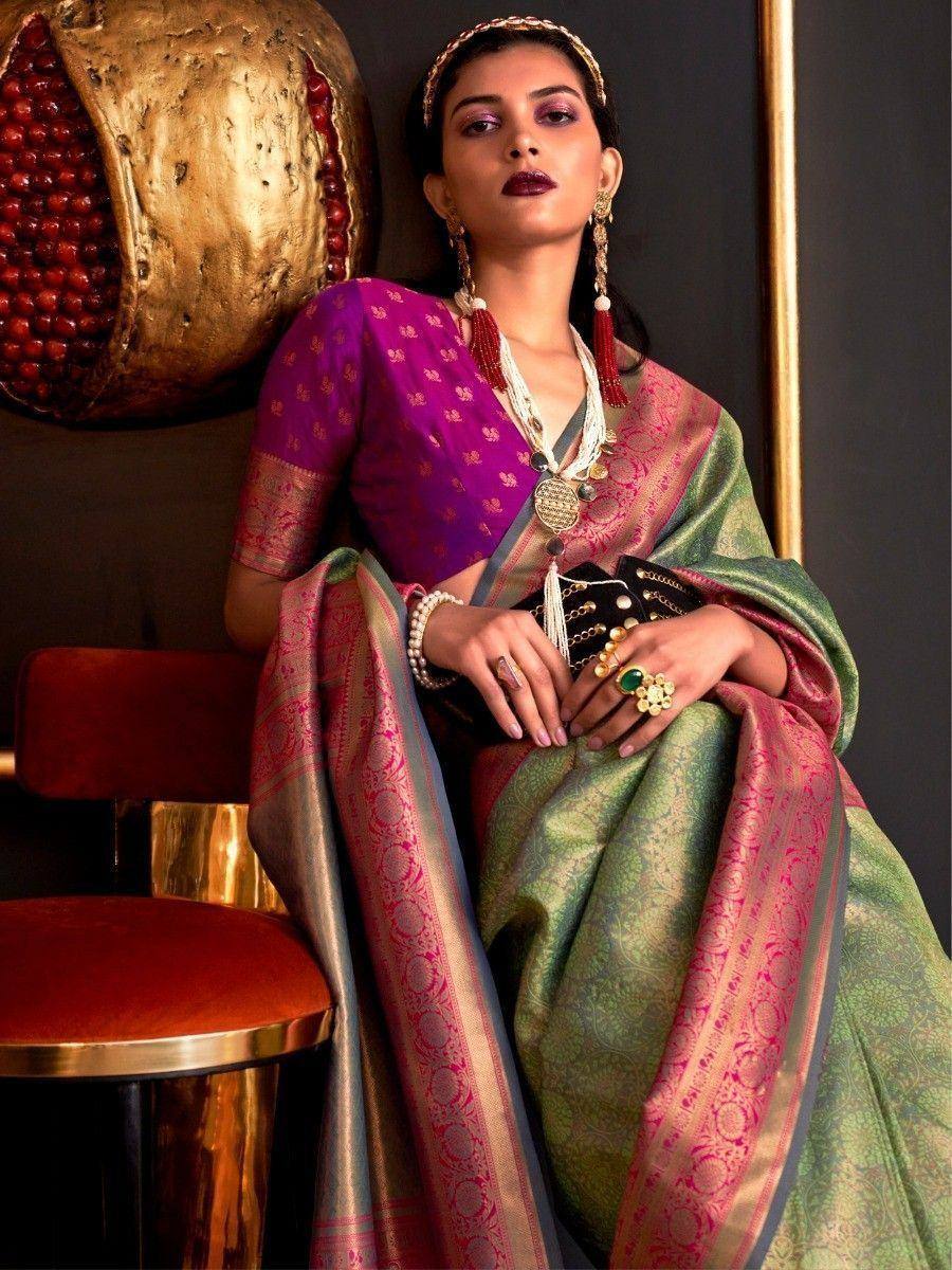 Woman in purple and green designer saree with gold embroidery, traditional Indian ethnic wear