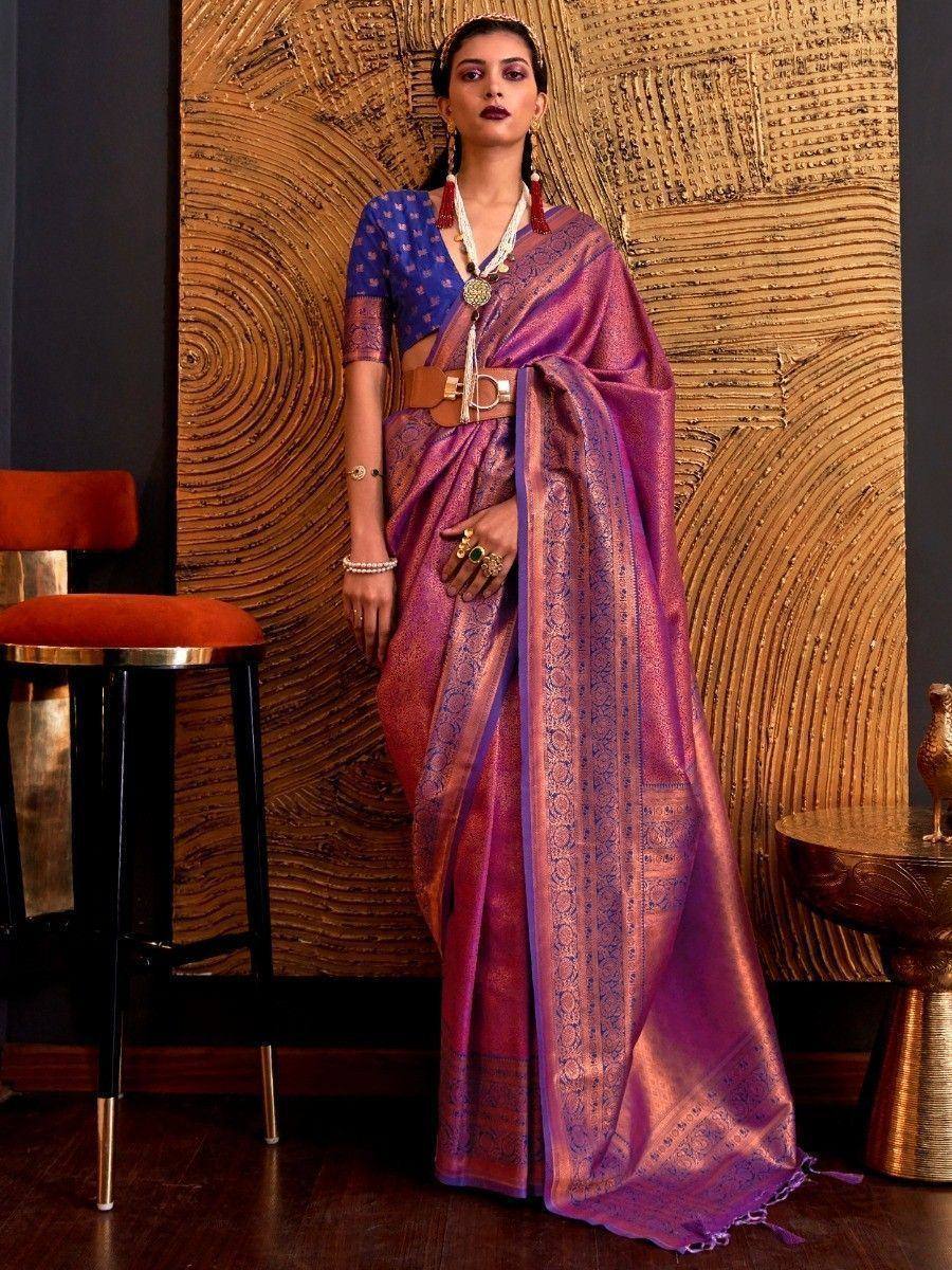 Purple and blue designer saree with intricate patterns, paired with a matching blouse and statement jewelry