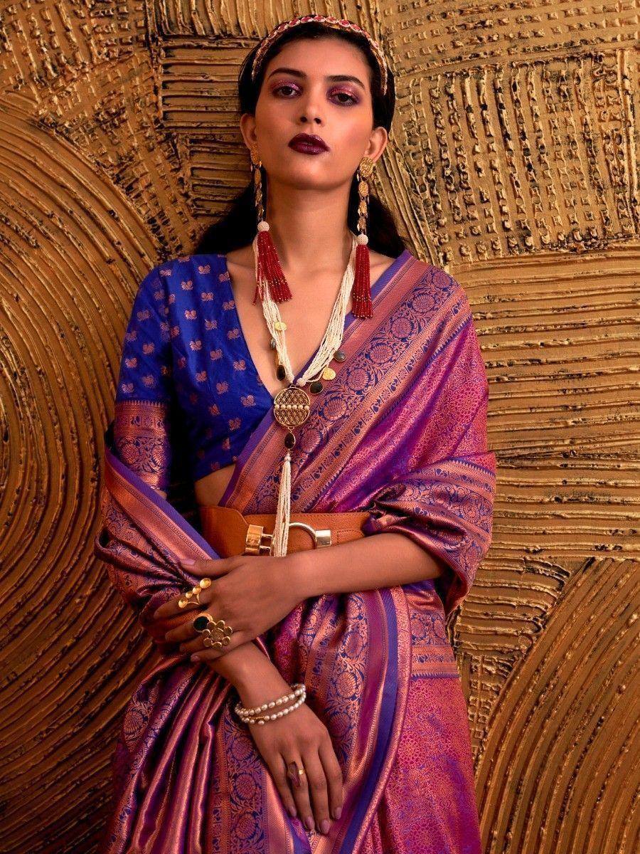 Elegant purple and blue designer saree with gold embroidery, paired with statement jewelry and a belt, perfect for ethnic occasions.