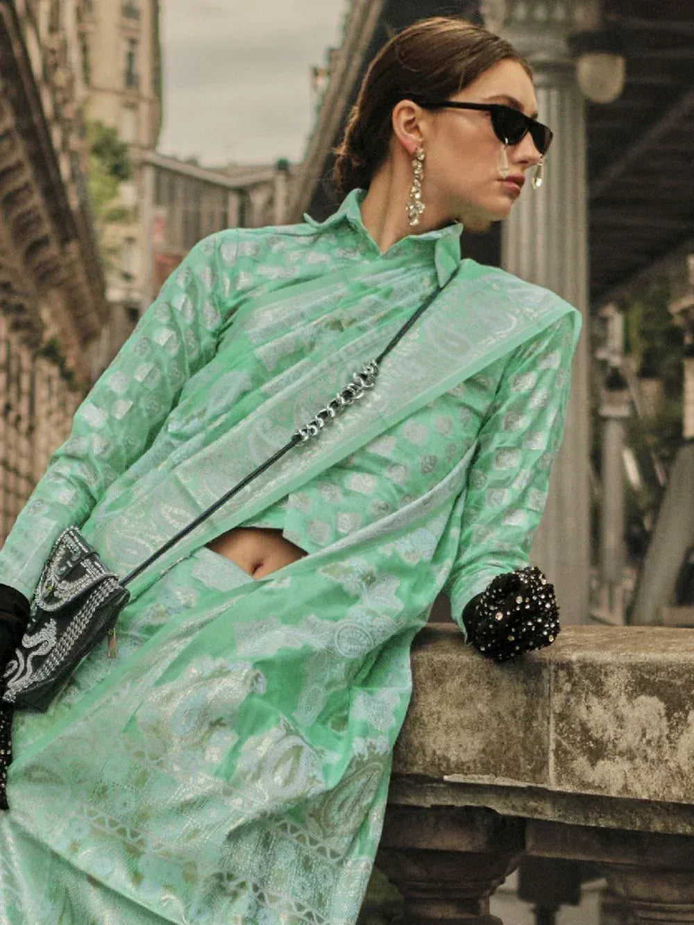 Mint green printed saree with blouse, styled with black embellished gloves and chain strap bag for ethnic wear
