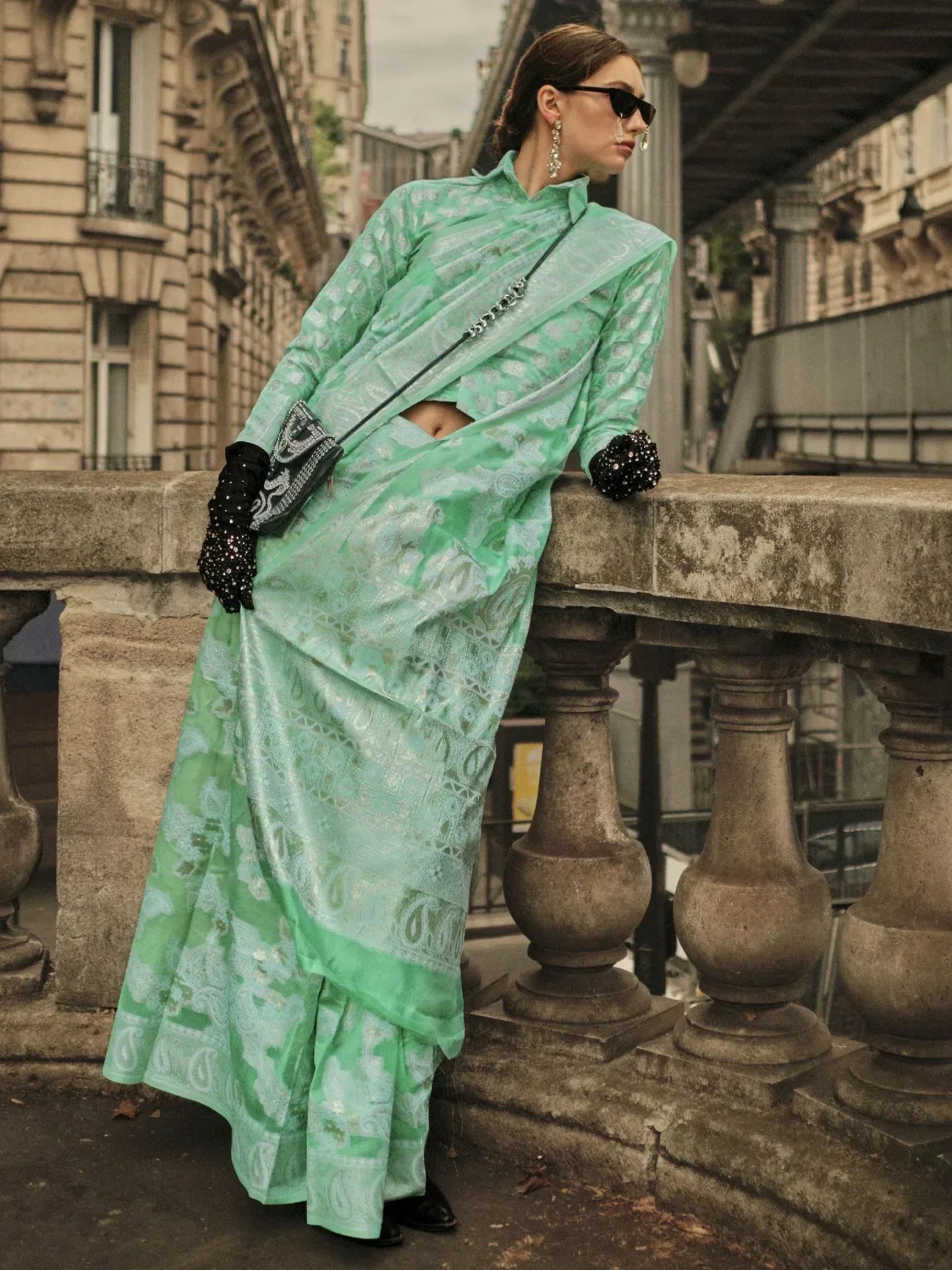 Mint green printed saree with modern blouse, styled with black gloves and chain bag for ethnic fashion