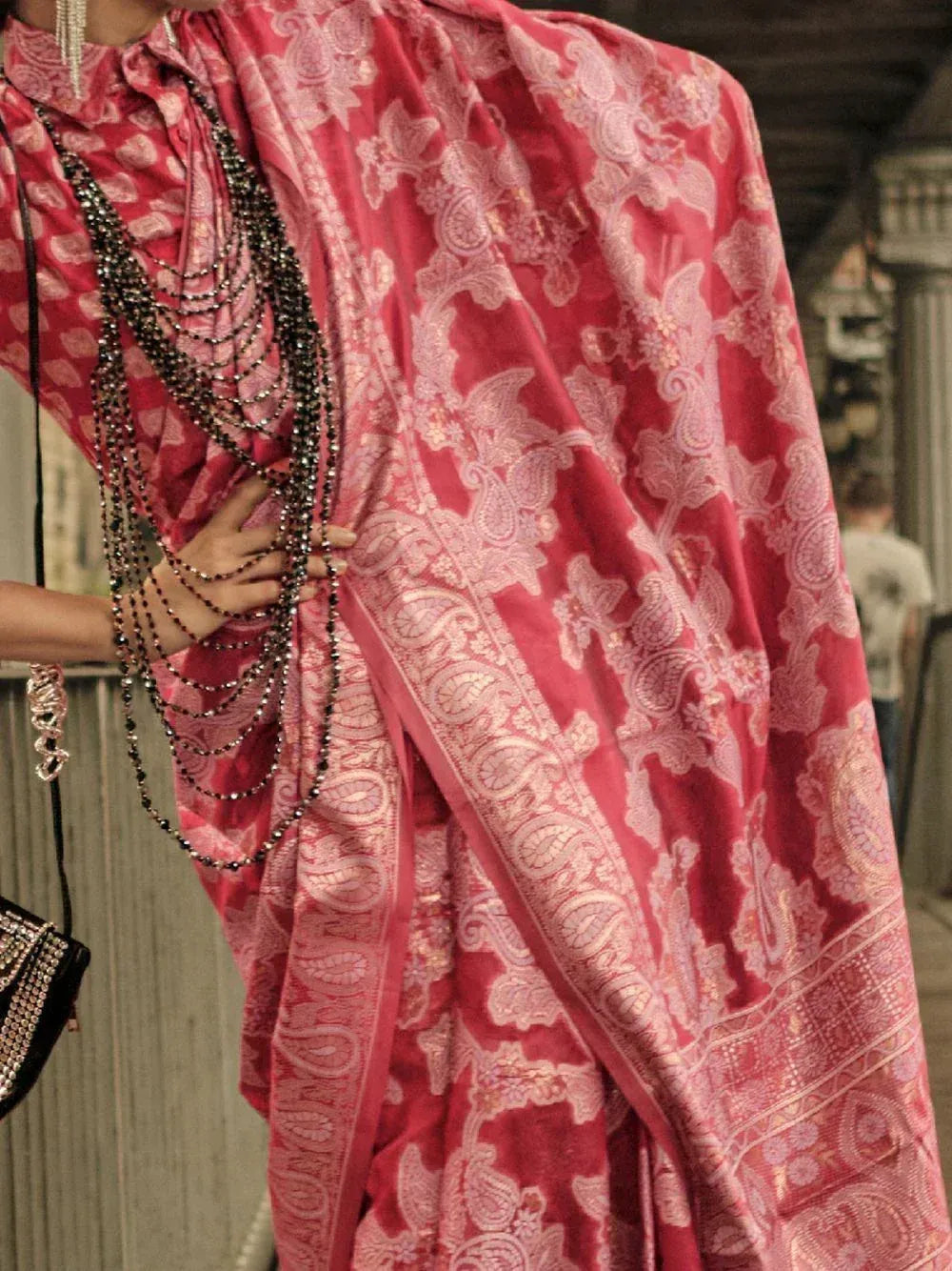 Pink paisley print saree with intricate embroidery, styled with layered beaded necklaces for ethnic wear