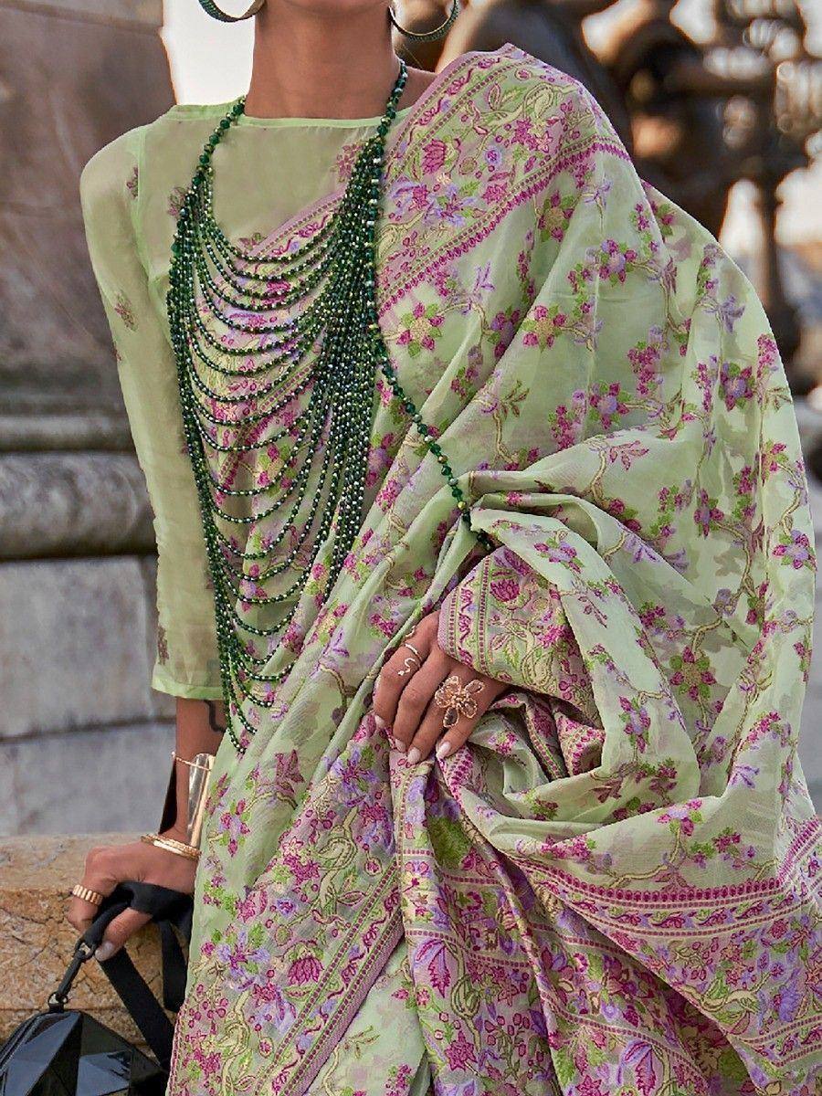 Light green floral saree with pink embroidery, paired with layered green bead necklace and gold jewelry