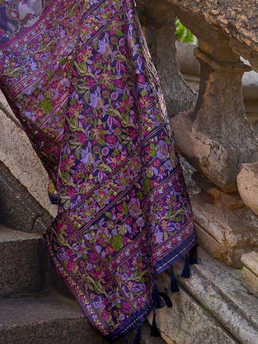 Purple floral ethnic saree with tassels draped on stone steps