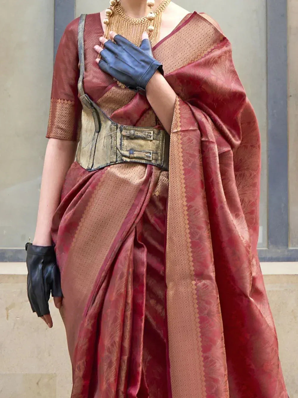 Red and gold designer saree with metallic corset, statement necklace, and black gloves for ethnic wear