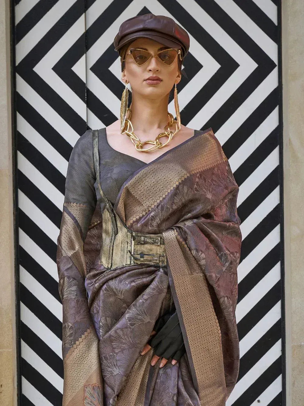 Stylish woman in designer ethnic saree with gold jewelry and cap, modern Indian fashion