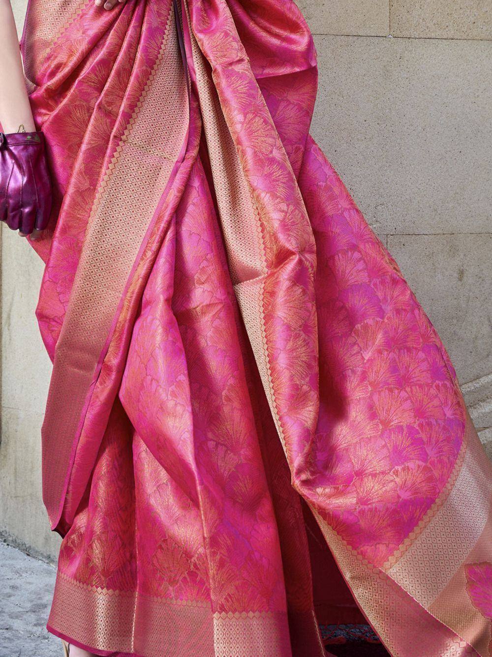 Pink silk saree with gold floral motifs and woven border, styled with purple gloves