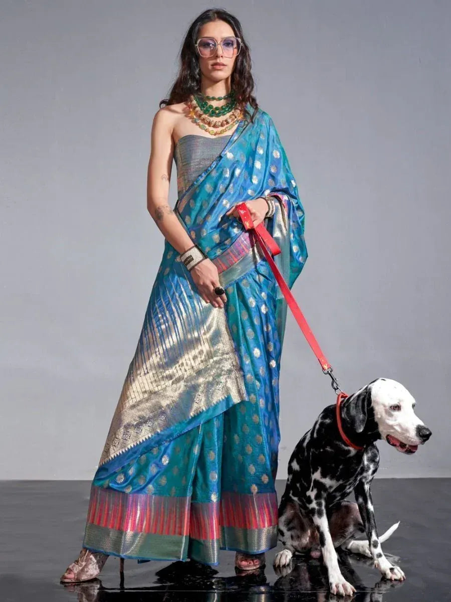 Woman in blue designer saree with gold motifs, holding Dalmatian on red leash, ethnic wear fashion