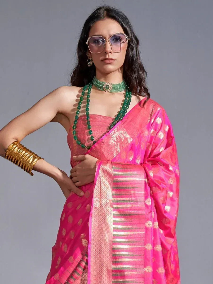 Pink designer saree with gold motifs, green beads, and gold bangles for ethnic wear