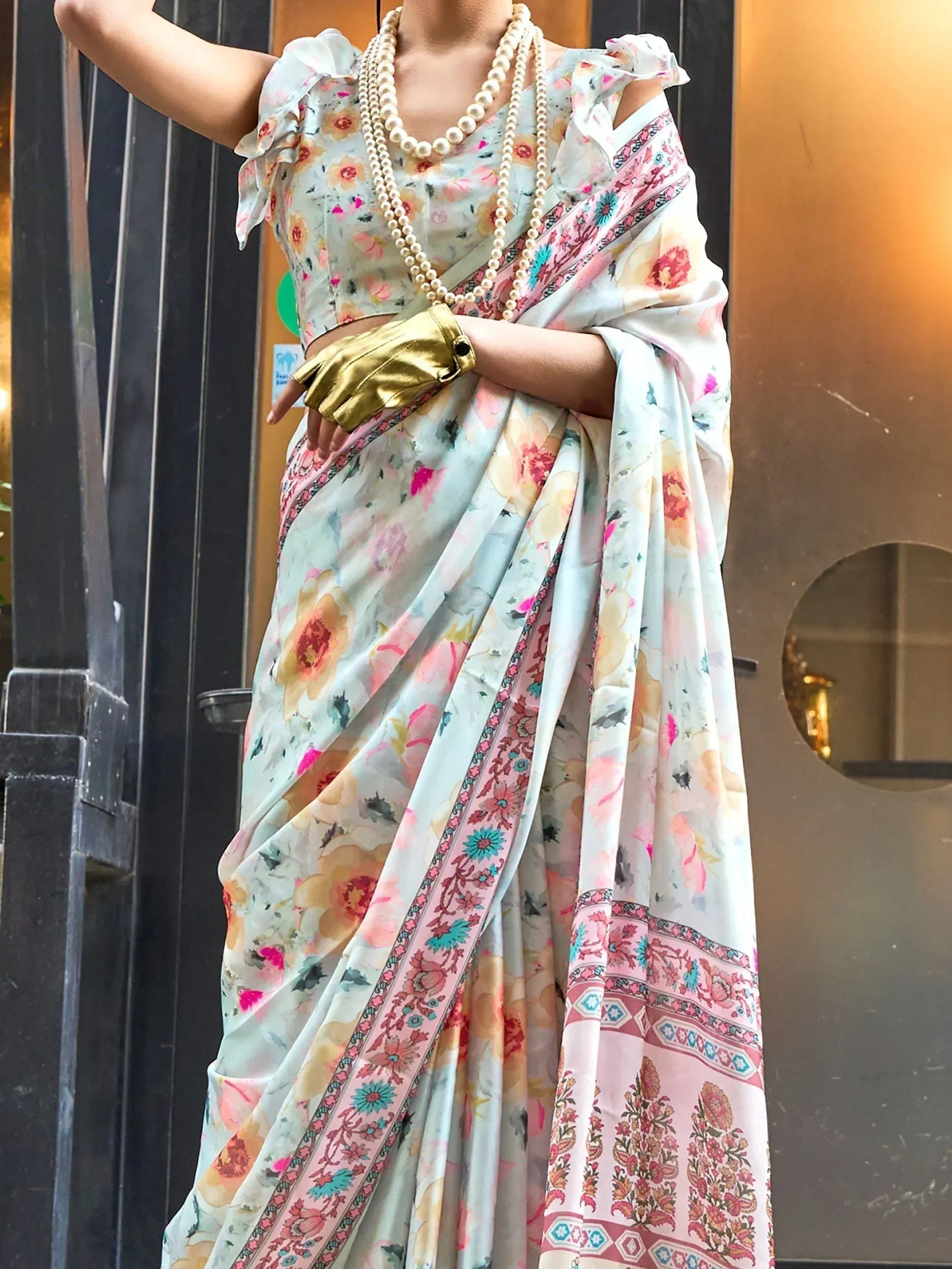 Floral print saree with ruffled blouse, pearl necklace, and gold glove for ethnic wear